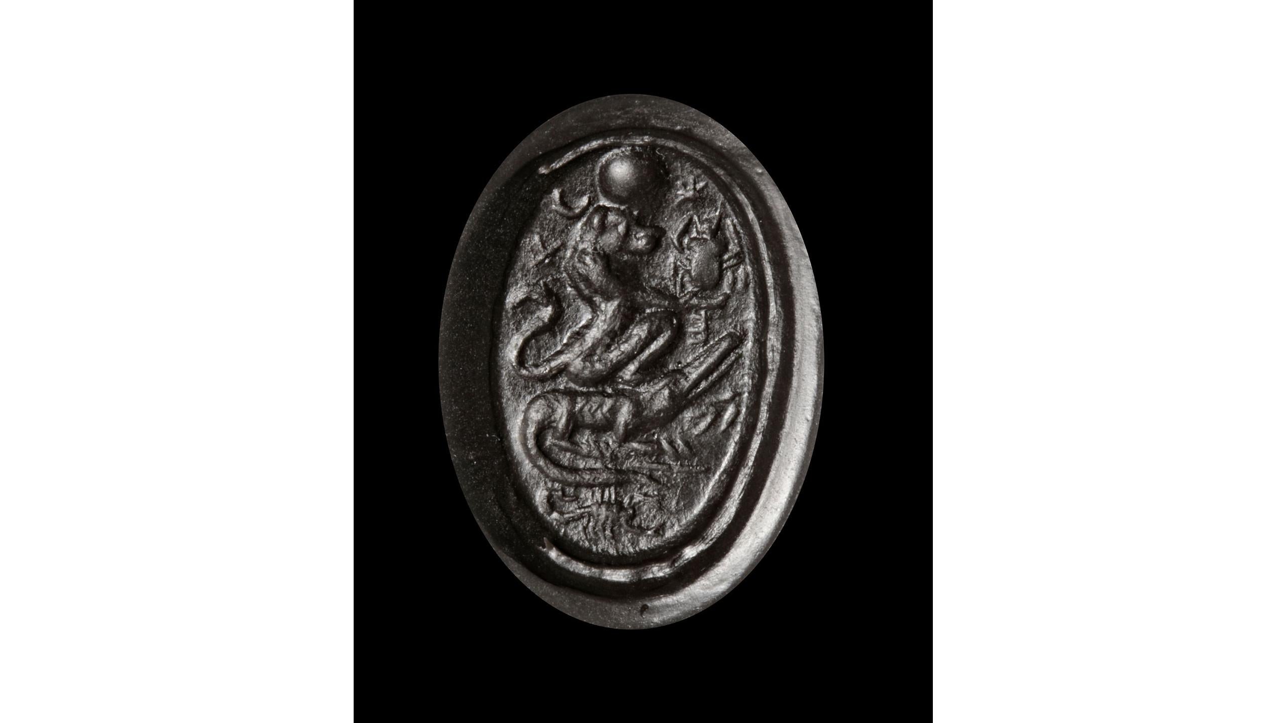 A Roman period magical or 'Gnostic' lapis lazuli intaglio with a seated lion with a solar disc holding a scarab, seated on a crocodile which in turn above a scorpion. On the reverse is a man headed lion holding his arms above his head with 'IAW'