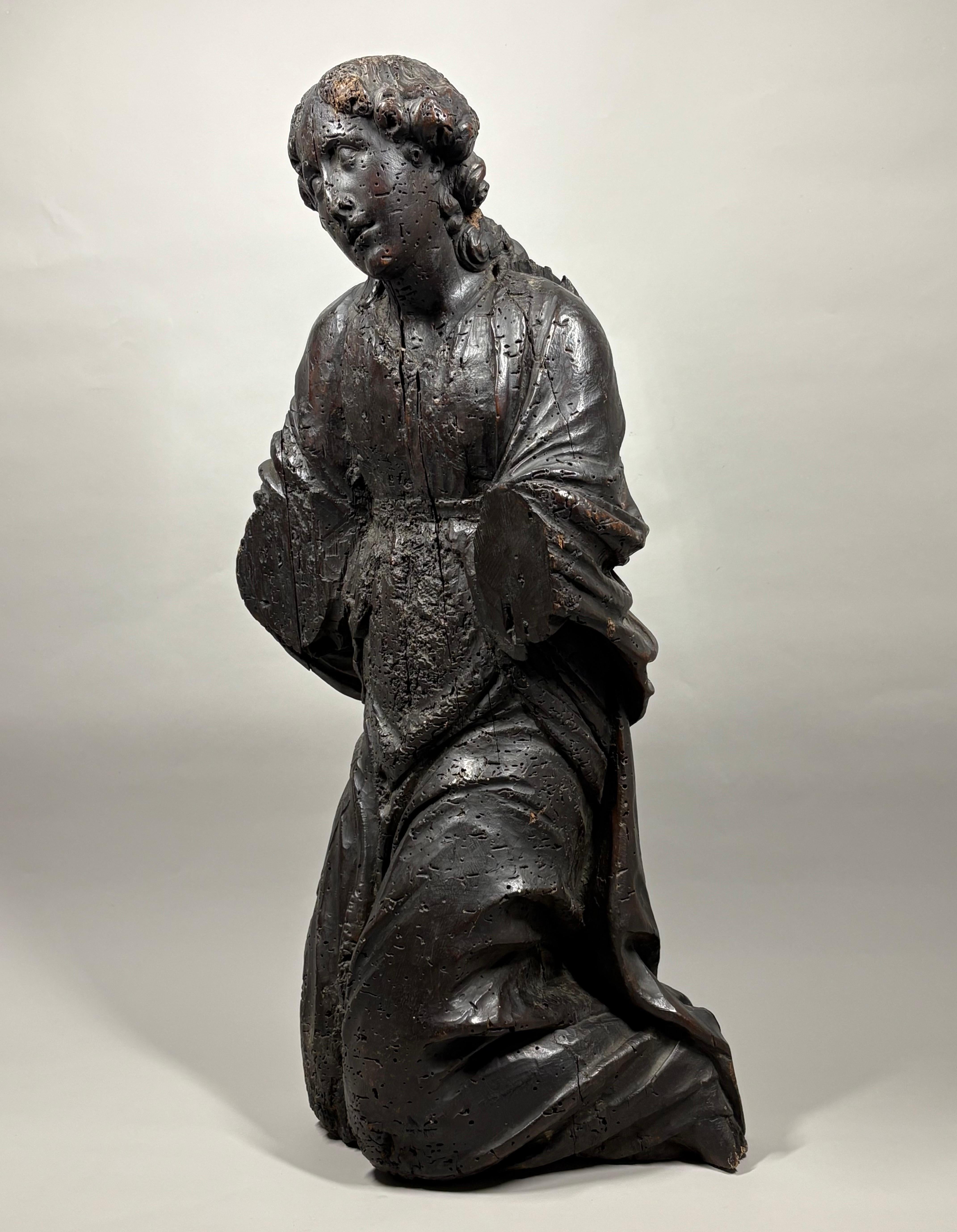 Un grande frammento di legno intagliato a mano del XVI secolo che raffigura un angelo inginocchiato in adorazione, con le braccia allargate e un'espressione dolce e serena. Probabilmente di origine nordeuropea, questa figura faceva parte di un