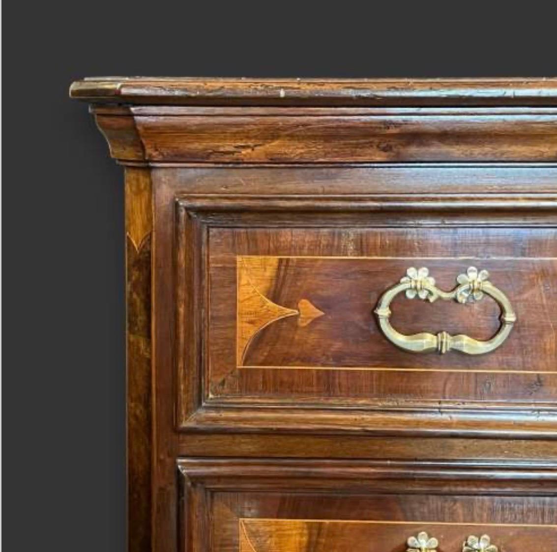 A Large 18th century Northern Italian chest of drawers. 
Three large drawers with faux double fronts. Inlaid accents to the drawer fronts and canted corners. Standing on carved bracket feet. 
Superb quality fruitwood inlay and all original