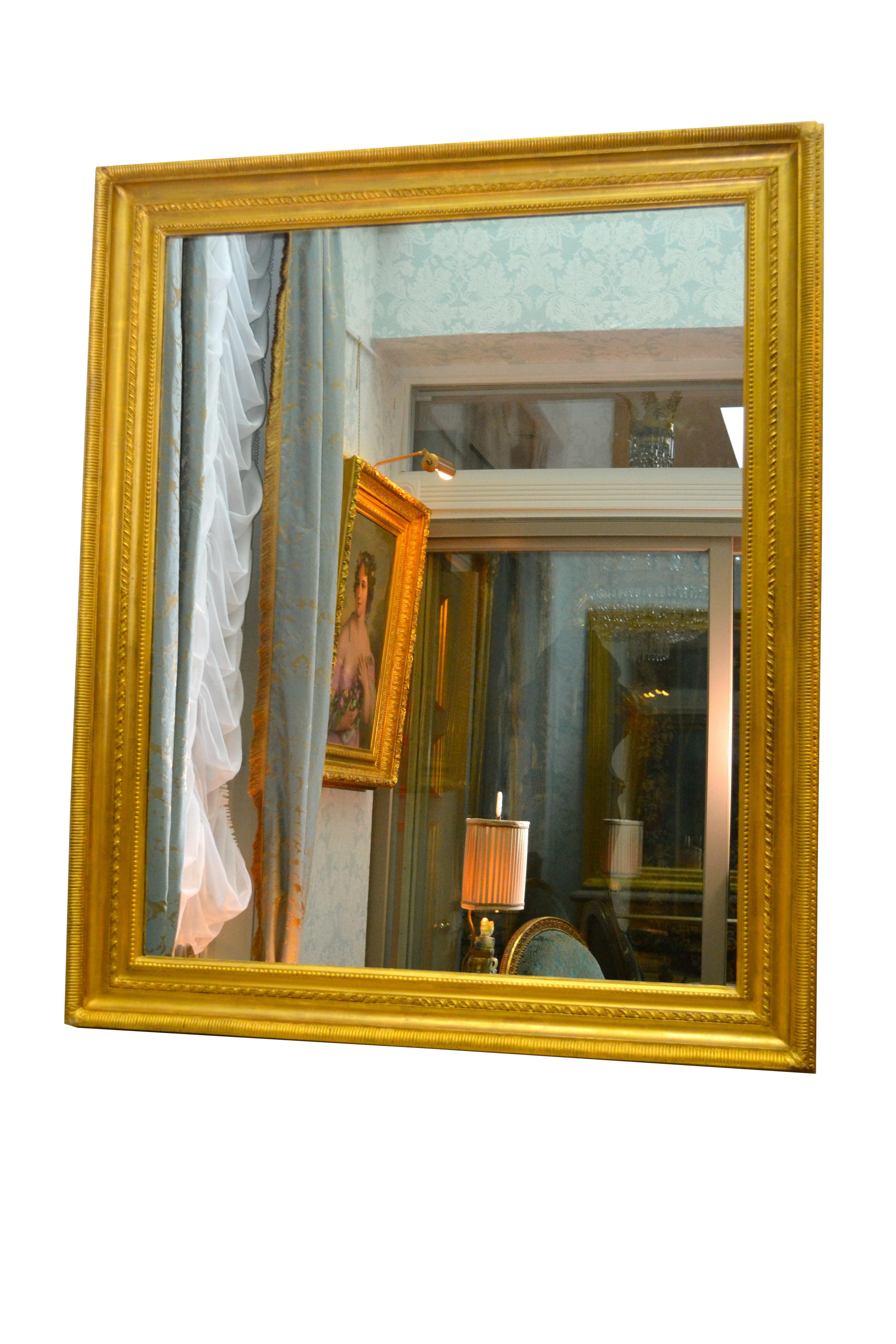 This is a simple rectangular modern mirror set in a robust 19th century giltwood frame perfect for over a mantel (fireplace) or simply hanging on a wall.
