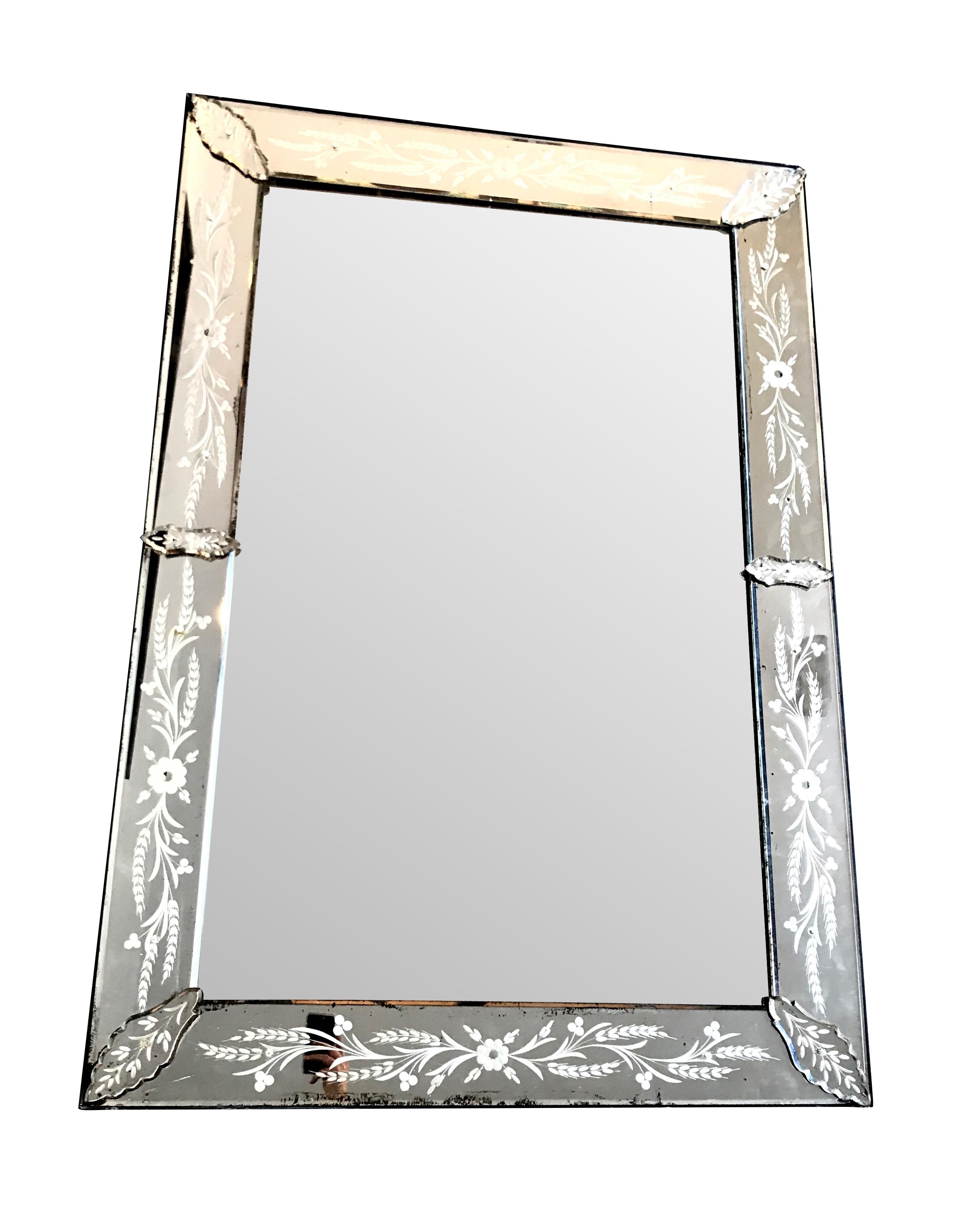A large 1920s Venetian mirror with etched mirrored frame with flowers, leaves and corn ears. On original wooden back and surrounding frame. It has the original mirror plate with some light foxing on the centre plate and surrounding mirror frame