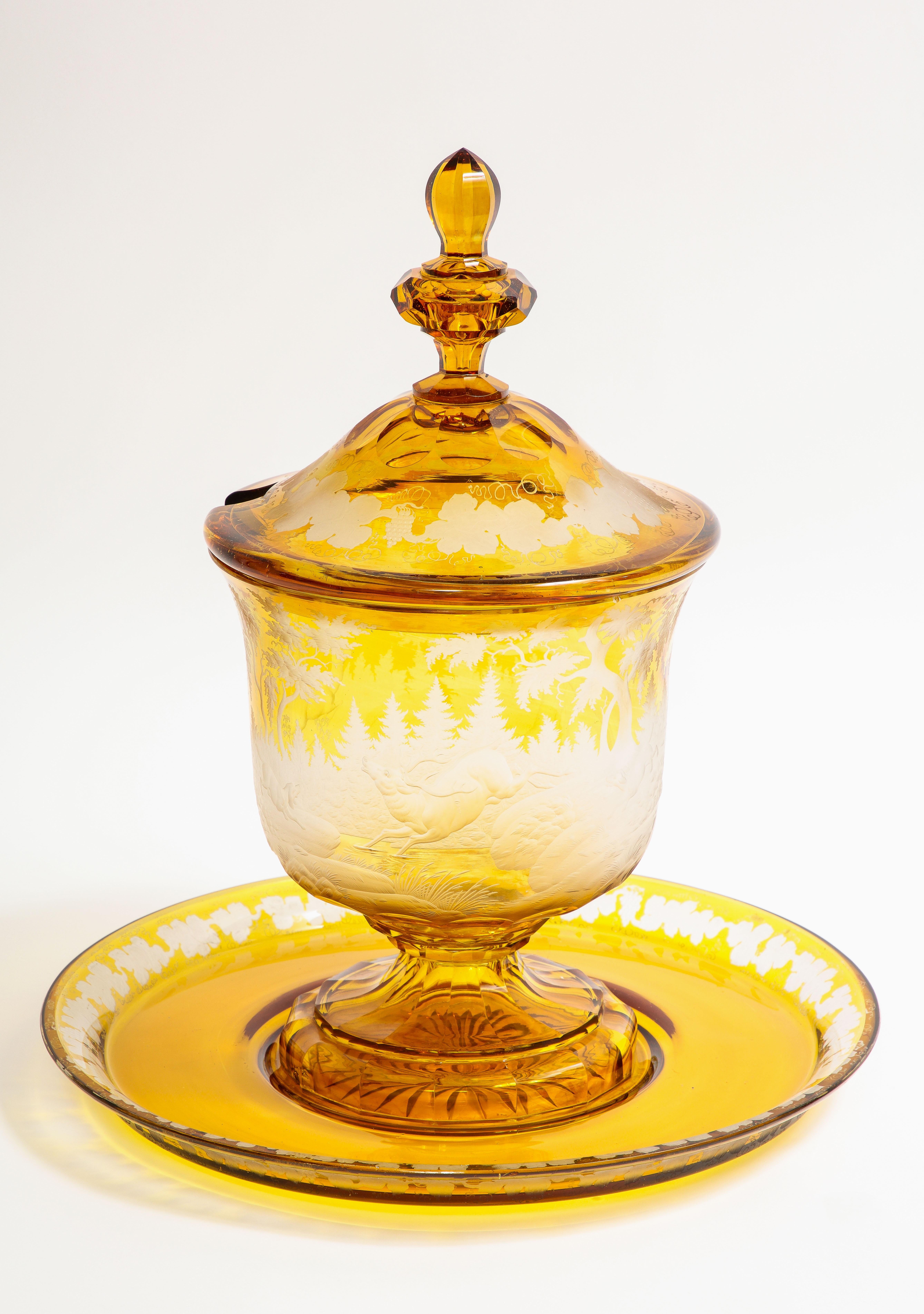 Spectaculaire et assez grand bol à punch du 19e siècle en cristal de Bohème ambré taillé et transparent avec des scènes de chasse et une sous-plaque. Ce merveilleux bol à punch en trois parties comprend une sous-plaque, un bol et un couvercle