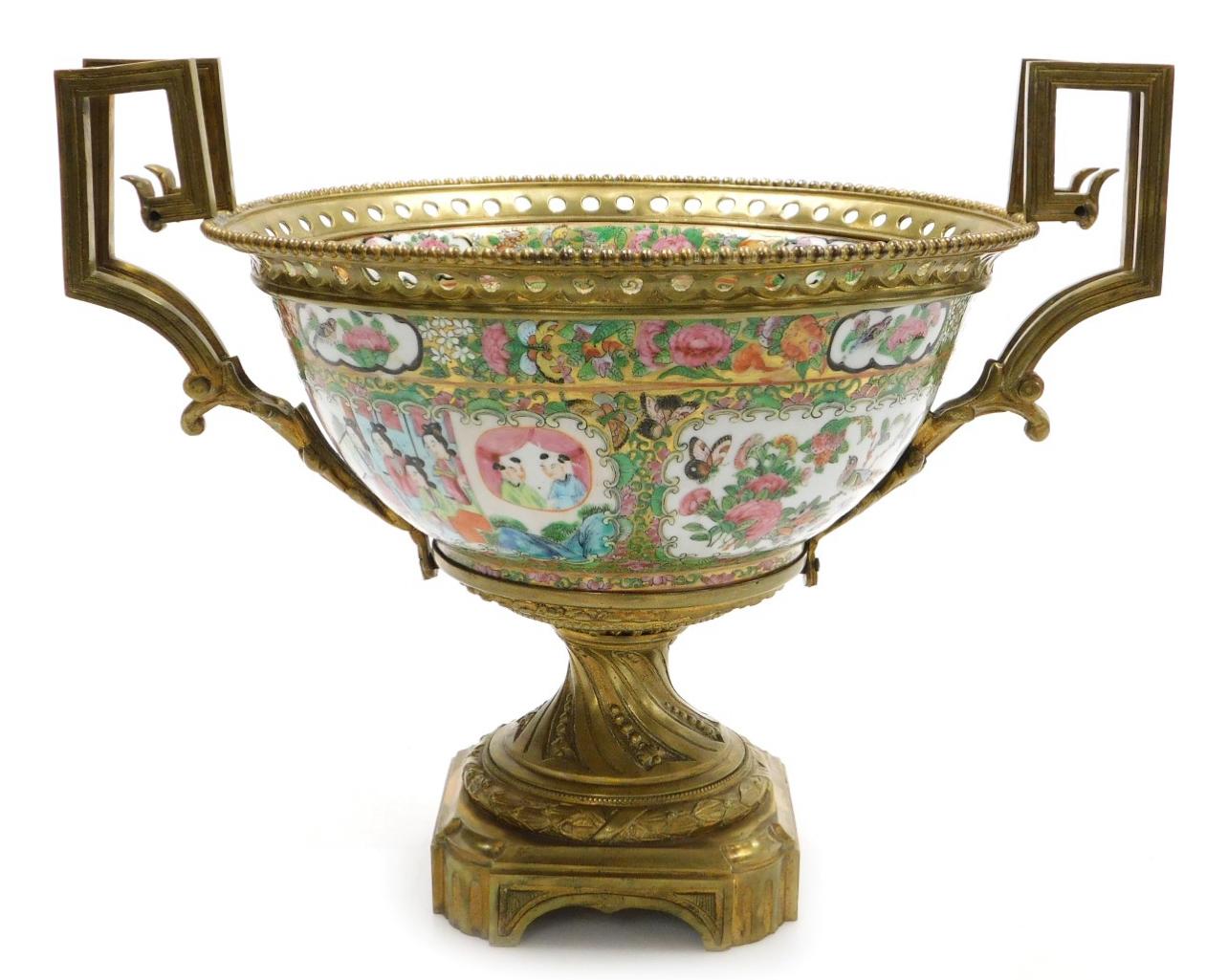 A Large 19th Century Cantonese famille rose porcelain and ormolu mounted bowl, with a beaded and pierced mount and angular scroll handles, the bowl decorated with reserves of figures, and birds, butterflies and flowers, within a gilt ground