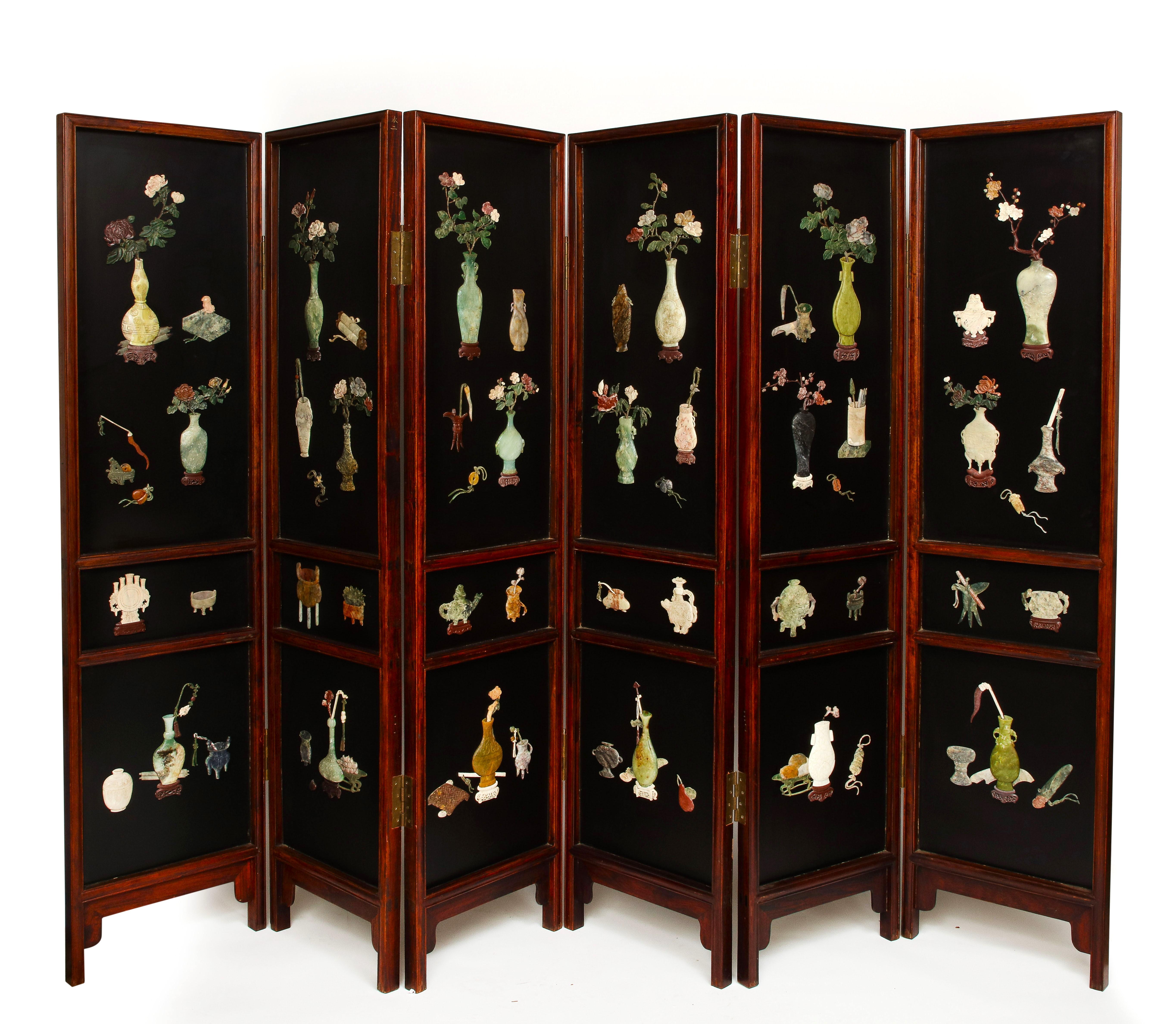 A large 20th century Chinese six panel Lacquered Hardstone and Jade Coromandel screen. This screen features intricately carved hardstone, soapstone, jade, lapis, quartz, and other hardstones from China. Each panel is is very large and has three