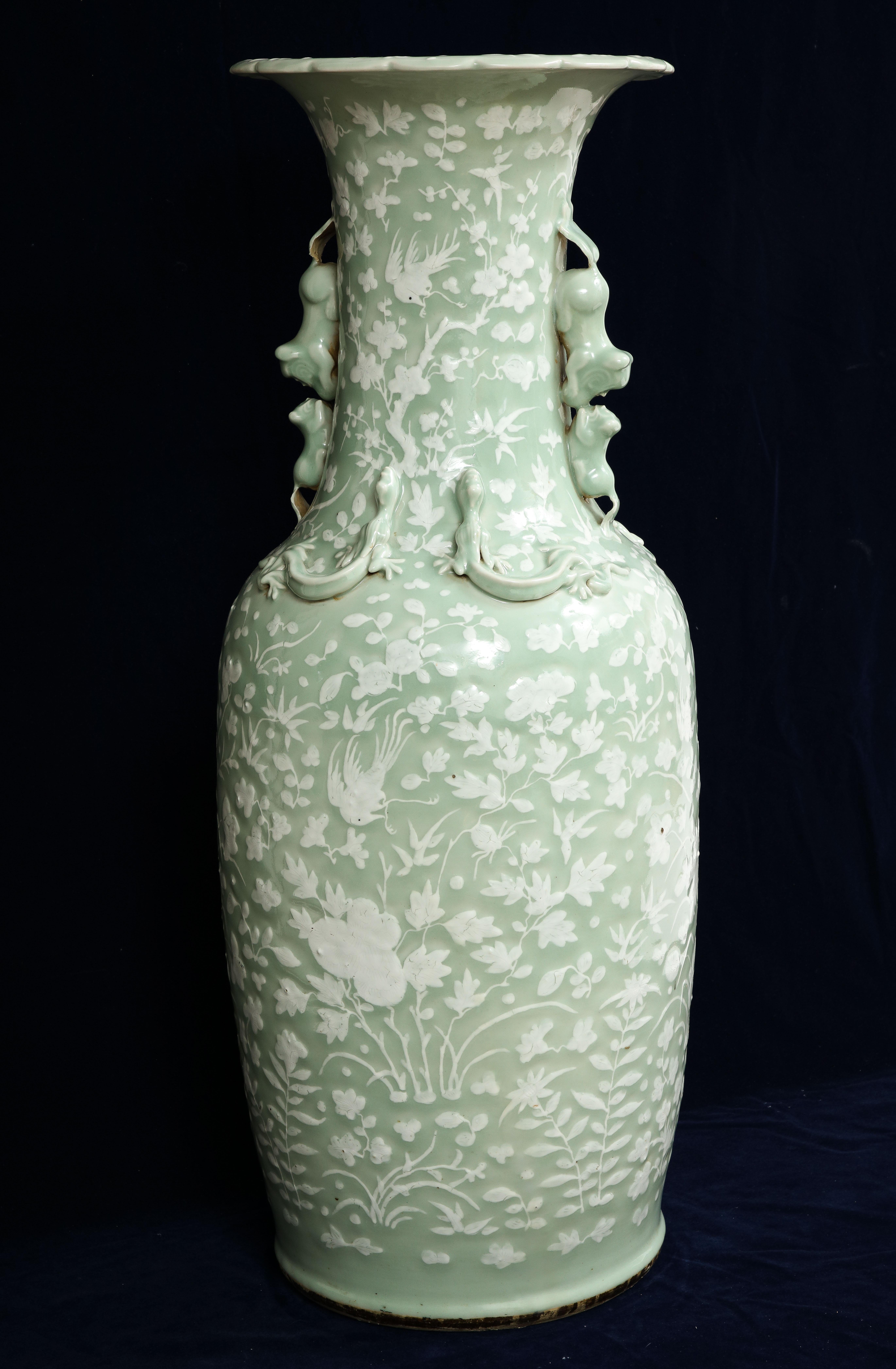 A Marvelous and Quite Large 19th Century Chinese Celadon-Ground slip-decorated vase with Foo Dog Handles. The piece is of baluster form and decorated throughout the body in white slip with incised details of butterflies, lotus blossoms, prunus and