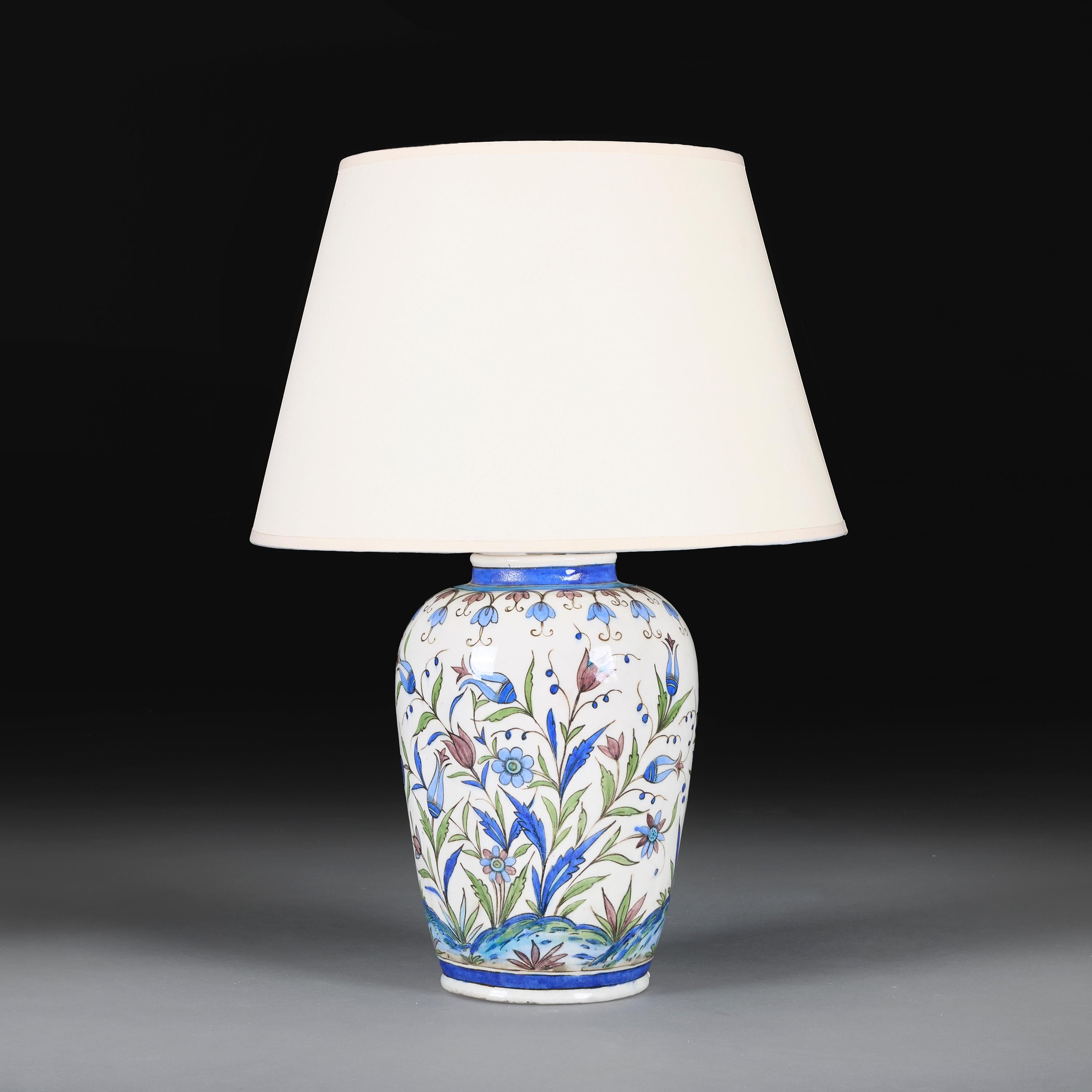 Persia, circa 1880

A large 19th century Iznik vase hand-painted with blue tulips and roses blossoming over rolling hills, now converted as a lamp.

Height 37.00cm

Diameter 23.00cm

Please note:

Lampshade not included. Lamp photographed with a 18”