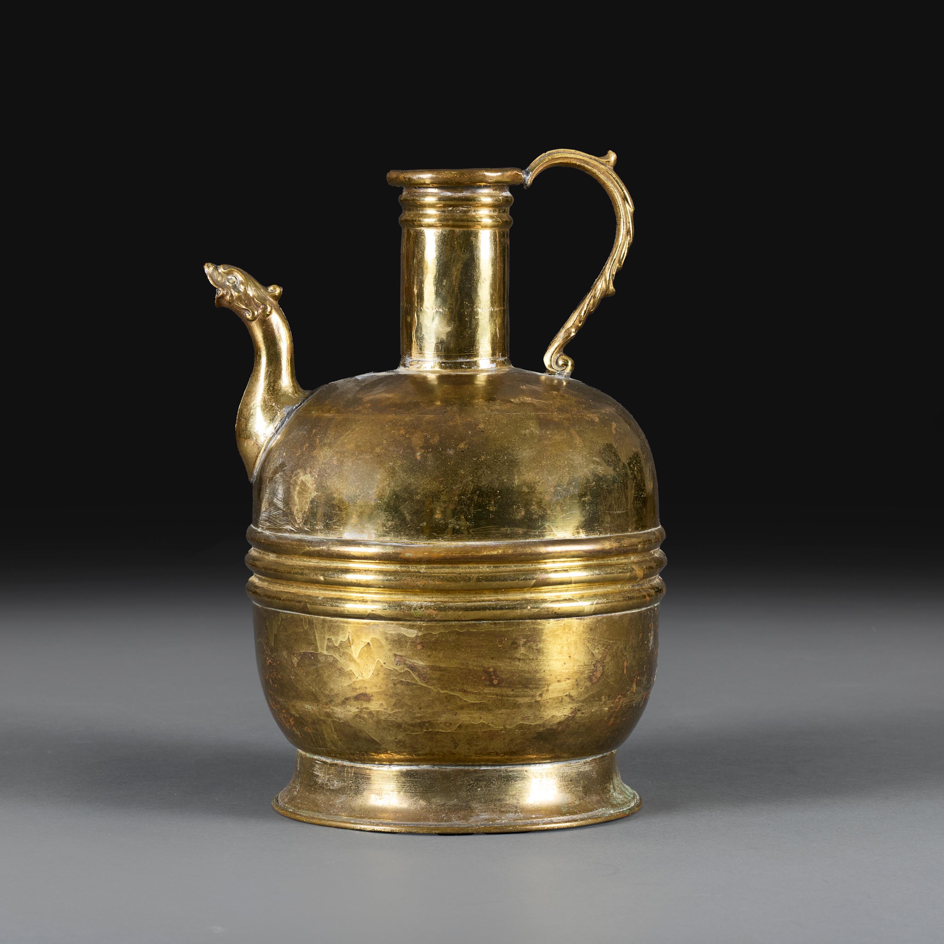 Paesi Bassi, circa 1890.

Un grande vaso in ottone della fine del XIX secolo, il corpo rigonfio con fascia centrale e beccuccio zoomorfo, il collo allungato con manico ricurvo, il tutto sostenuto da una base circolare strombata.

Altezza 41,50