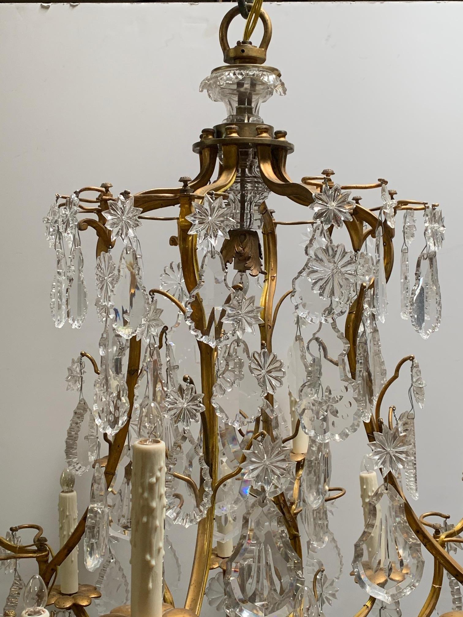 A large 19th century bronze dore and crystal chandelier The grand chandelier is from the late 19th century. This 16-light chandelier is constructed of gilded bronze with large cut crystals and a beveled sphere at the base.