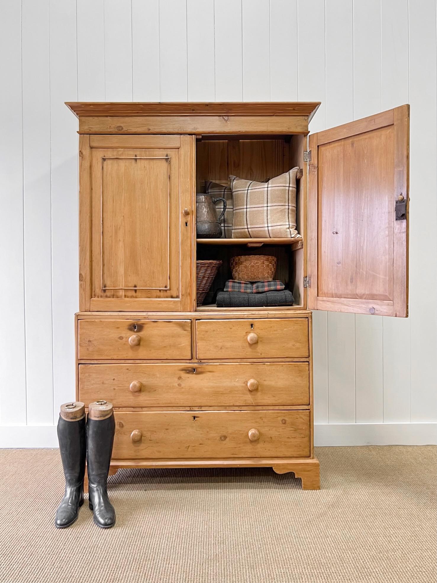 A large and very good antique English pine linen press cupboard. Top portion with stationary shelving. Lower portion with 2 over 2 drawer configuration.  Wooden knob hardware. Dovetail construction. The top is detachable from the bottom for ease of
