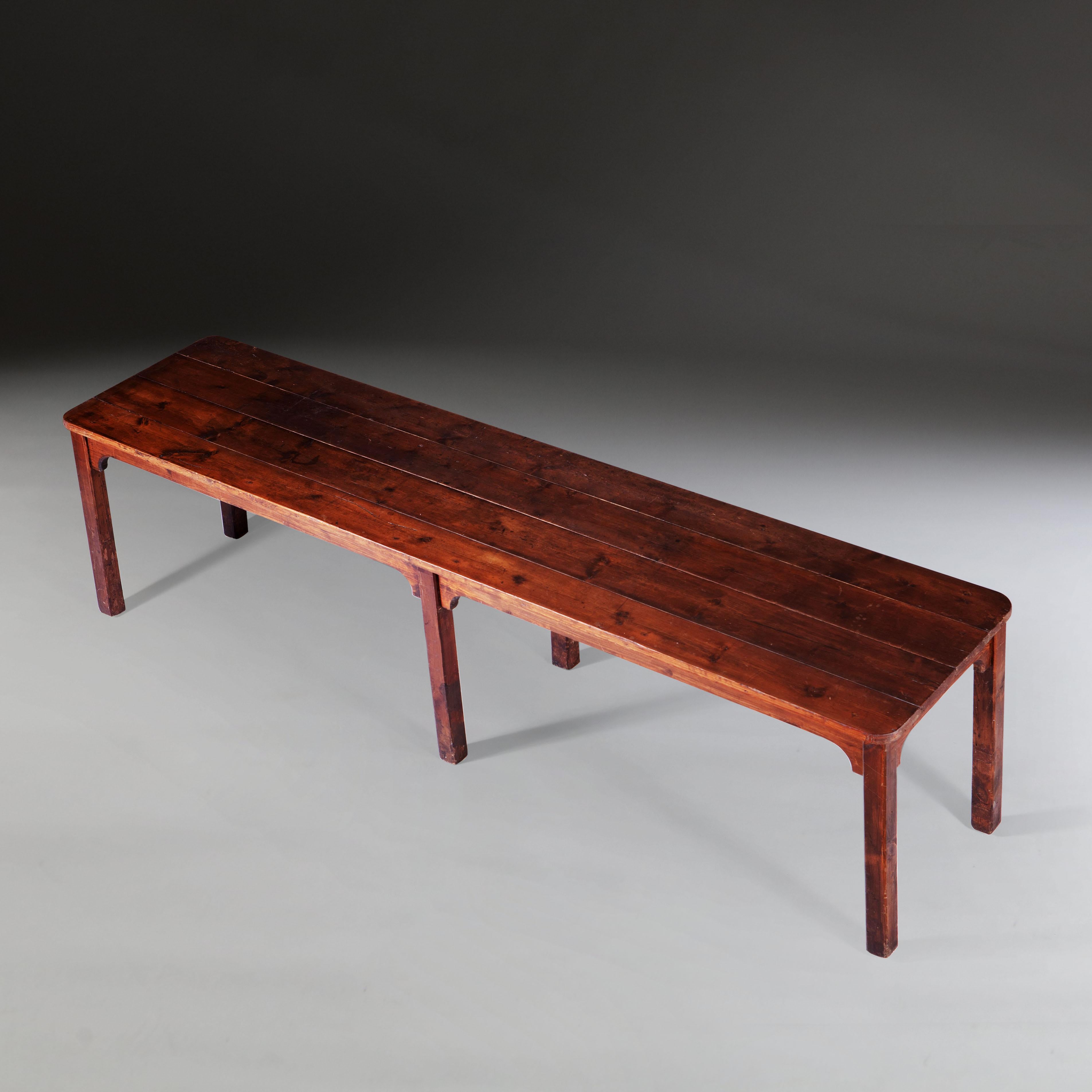 A very long 19th century farmhouse refectory table in pine, with slatted top and six legs.

 