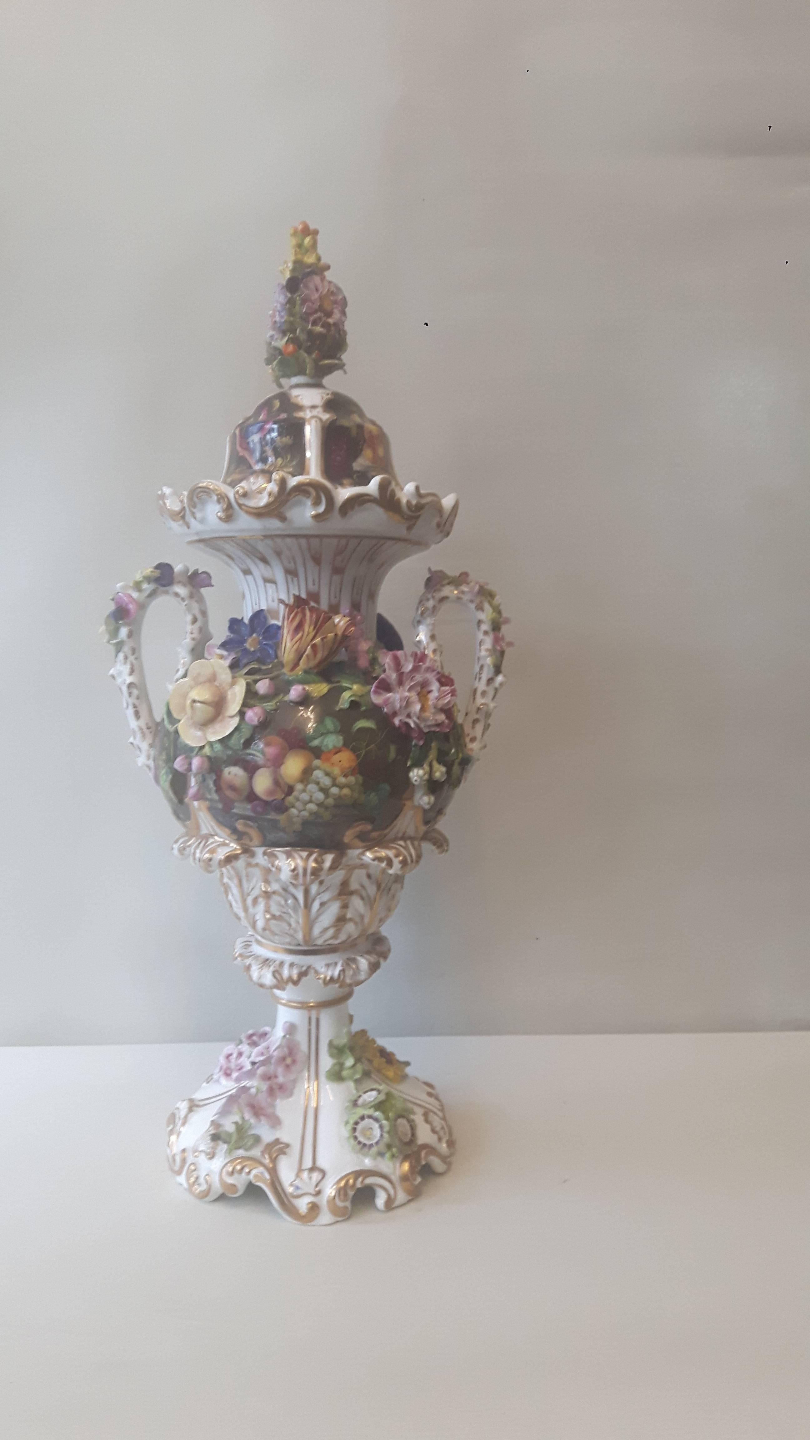 An elegant English porcelain vase and cover, first quarter of the 19th century, probably from the Derby factory, with hand-painted panels of birds and fruit and flower scenes, with encrusted flowers.