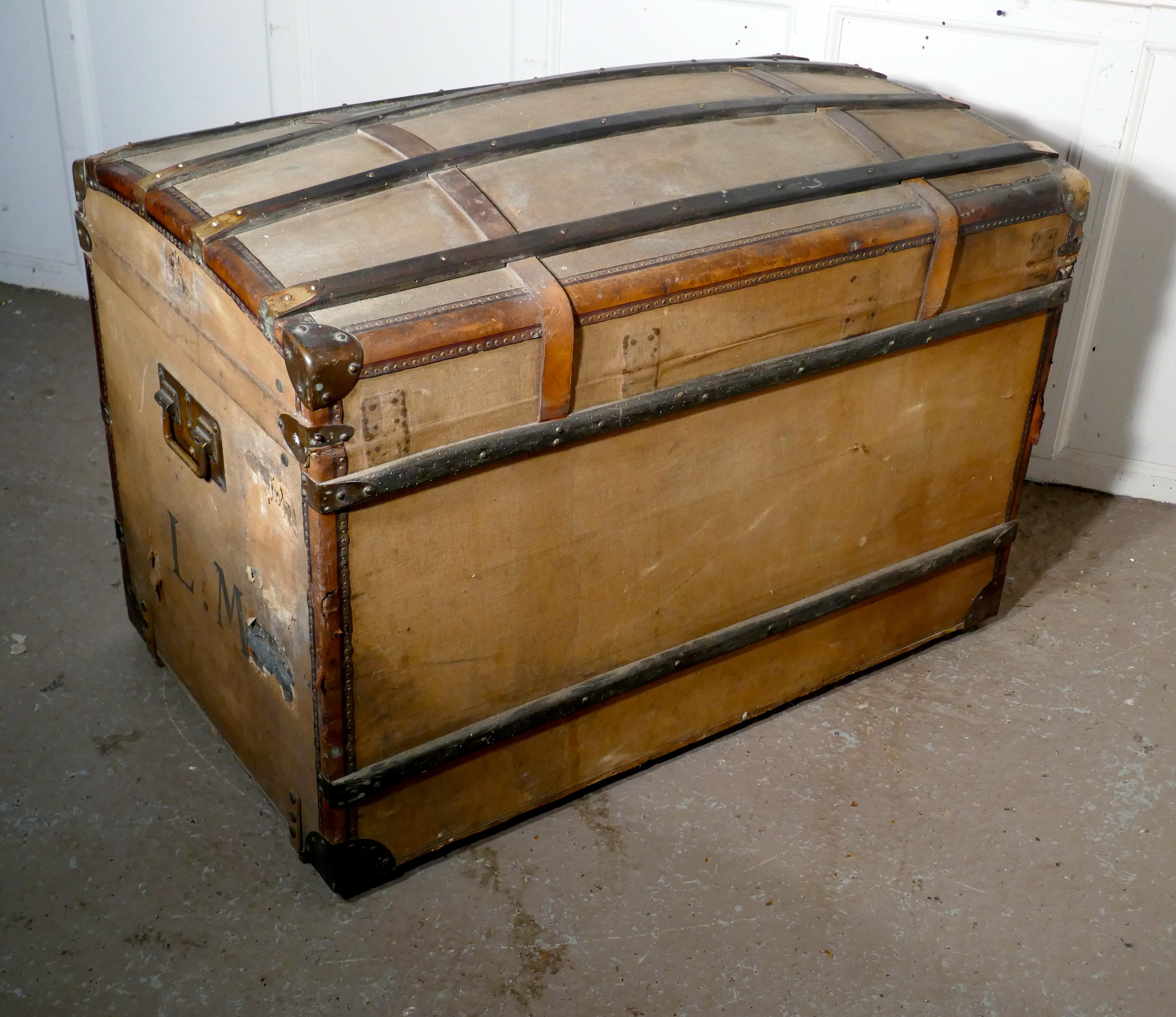 A large 19th century French canvas dome top travel trunk, lion brand

The trunk has a wooden carcass covered in canvas, it has wood and Leather banding with decorative brass metal work around all the edges. The trunk has brass carrying handles and