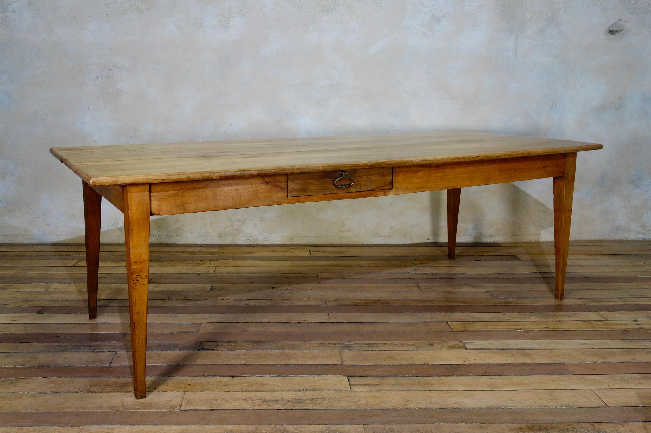 A 19th century French fruitwood farmhouse table, displaying a cleated four plank top with a single frieze drawer. Raised on elegantly shaped tapered legs, with historic repairs to the base of the legs.

Measures: Height 75cm
Apron height