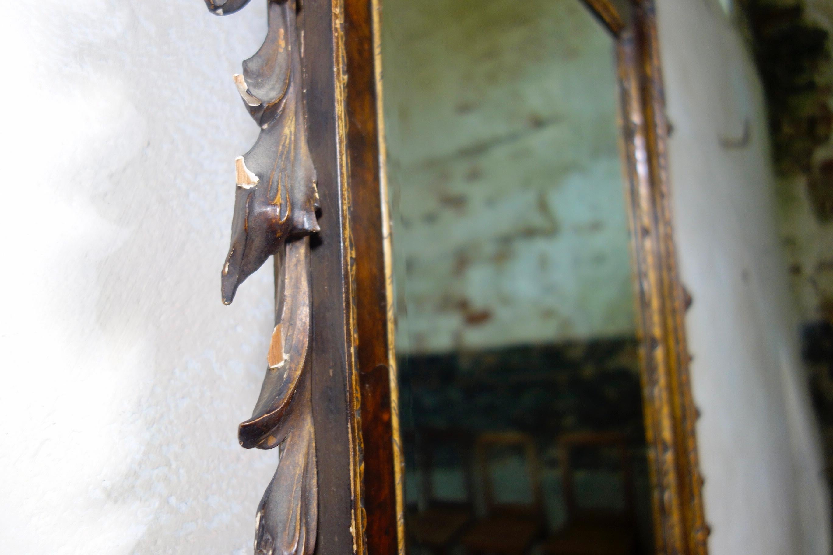 A large striking 19th century George II style mahogany and gilt frame mirror. Featuring the original, bevelled edge mirror with some foxing within a carved egg and dart outer frame.
Featuring a classical shaped broken pediment above with carved