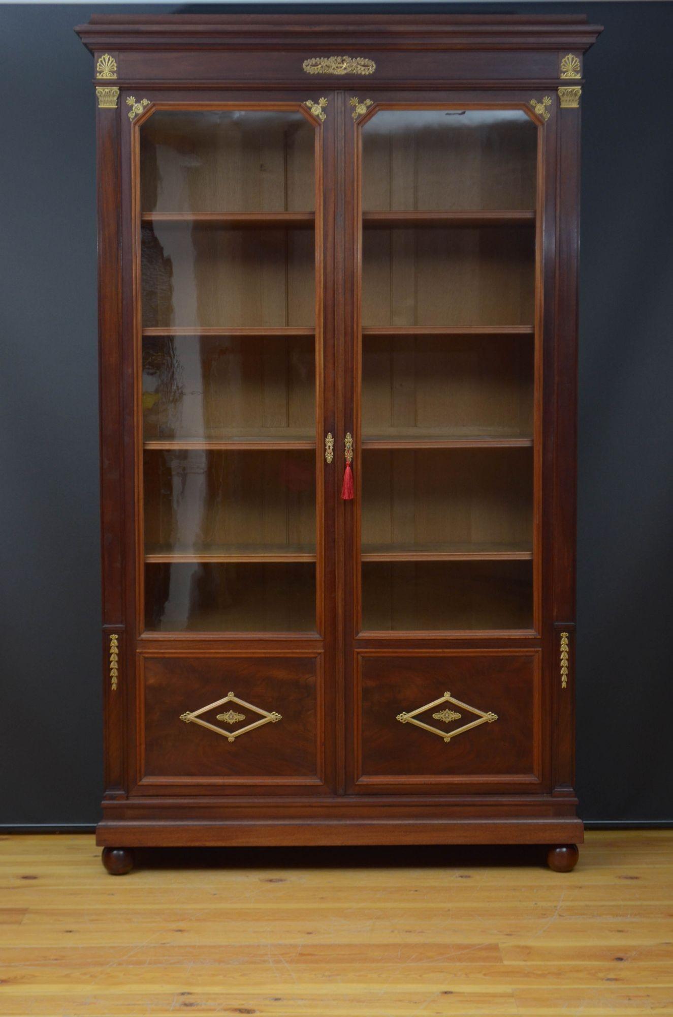Sn5534 A large XIXth century mahogany glazed bookcase, having cavetto cornice above a shallow frieze and a pair of glazed doors with flamed mahogany panels to the base and fitted with original working lock and enclosing five height adjustable