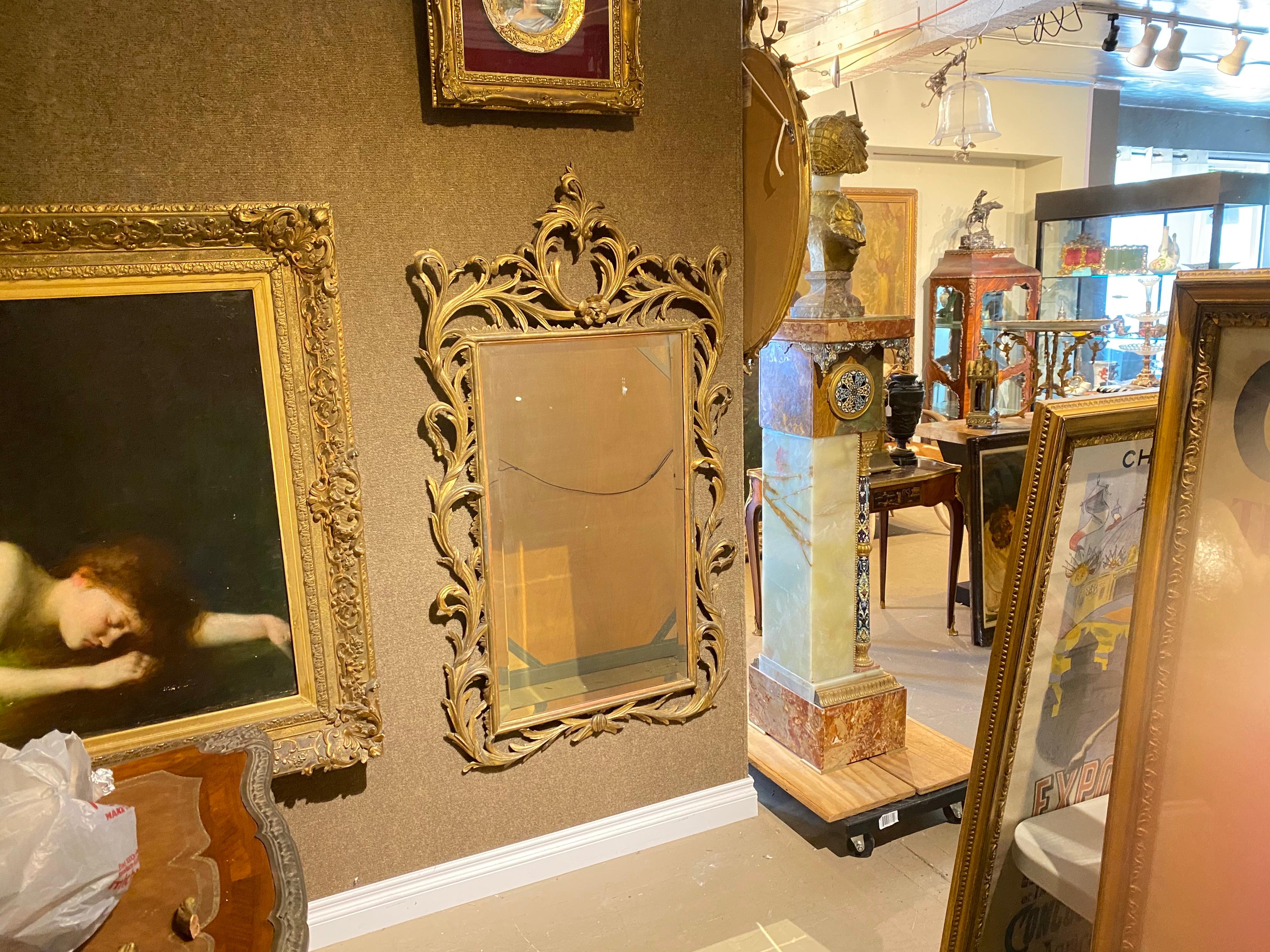 Miroir en bois doré de style sculpté de George III, vers 1880. 
Avec un verre biseauté et un fond argenté. La dorure est d'origine. 