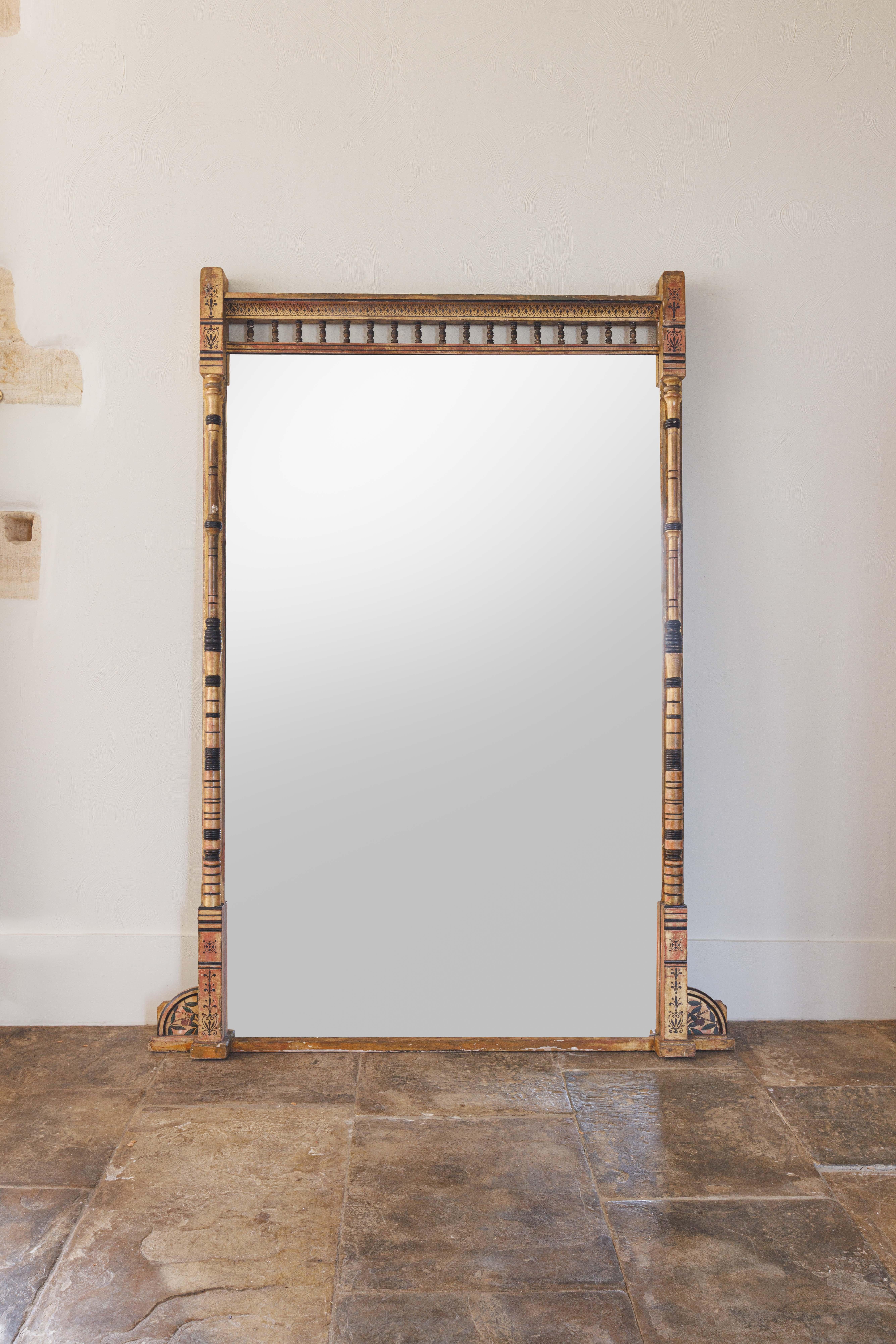 Miroir à trumeau du mouvement esthétique victorien, doré et ébonisé, avec sa plaque de miroir unie d'origine et une galerie à balustrade flanquée de supports à colonnes tournées et cannelées. La base est flanquée de consoles à volutes.

Le mouvement