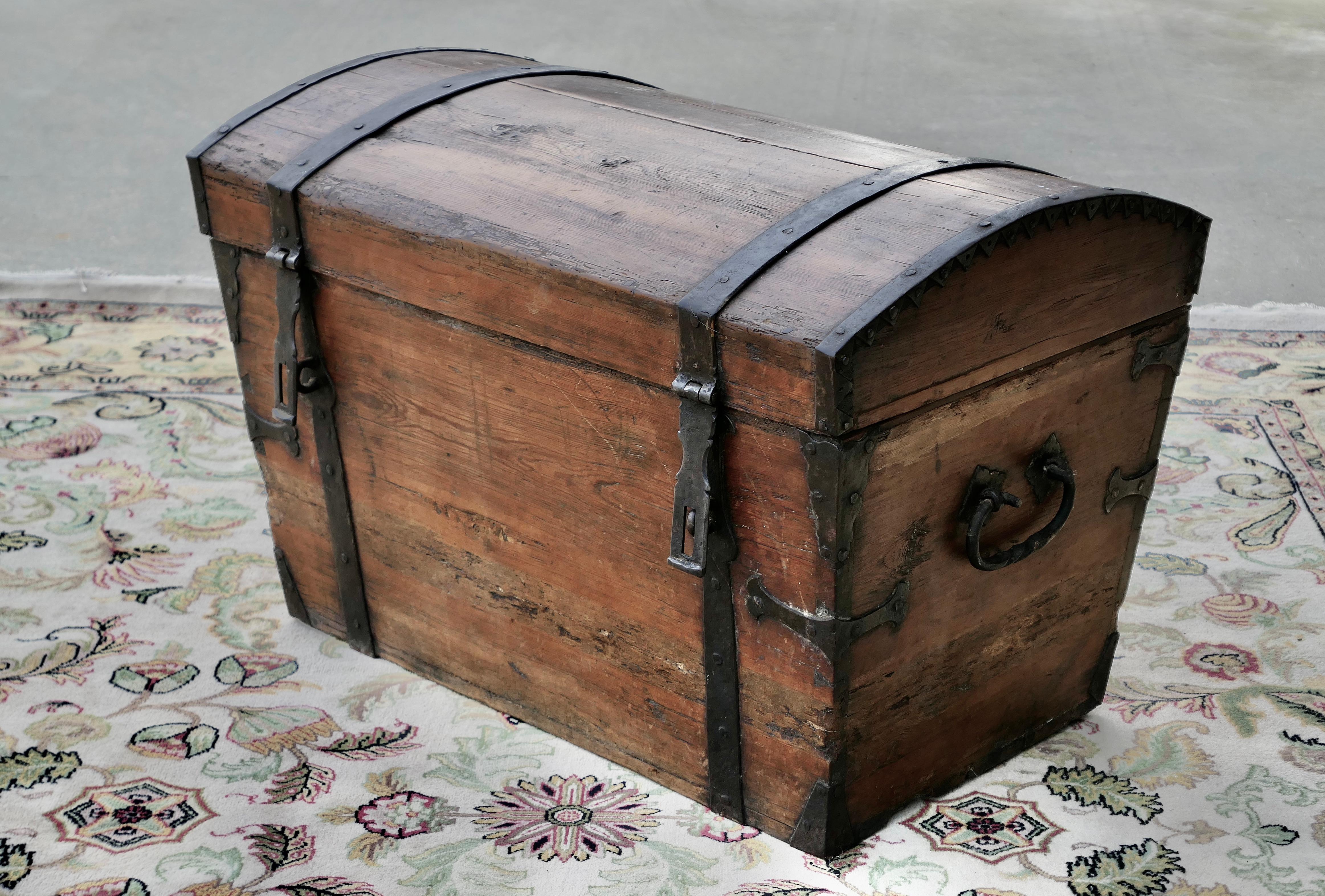 A Large 19th Century Pine Dome Top Trunk

This  trunk has a very attractive shape, it is made in naturally darkened pine and has very attractive heavy iron strapping metal work.  The trunk has strong carrying handles and hasps on the front, this