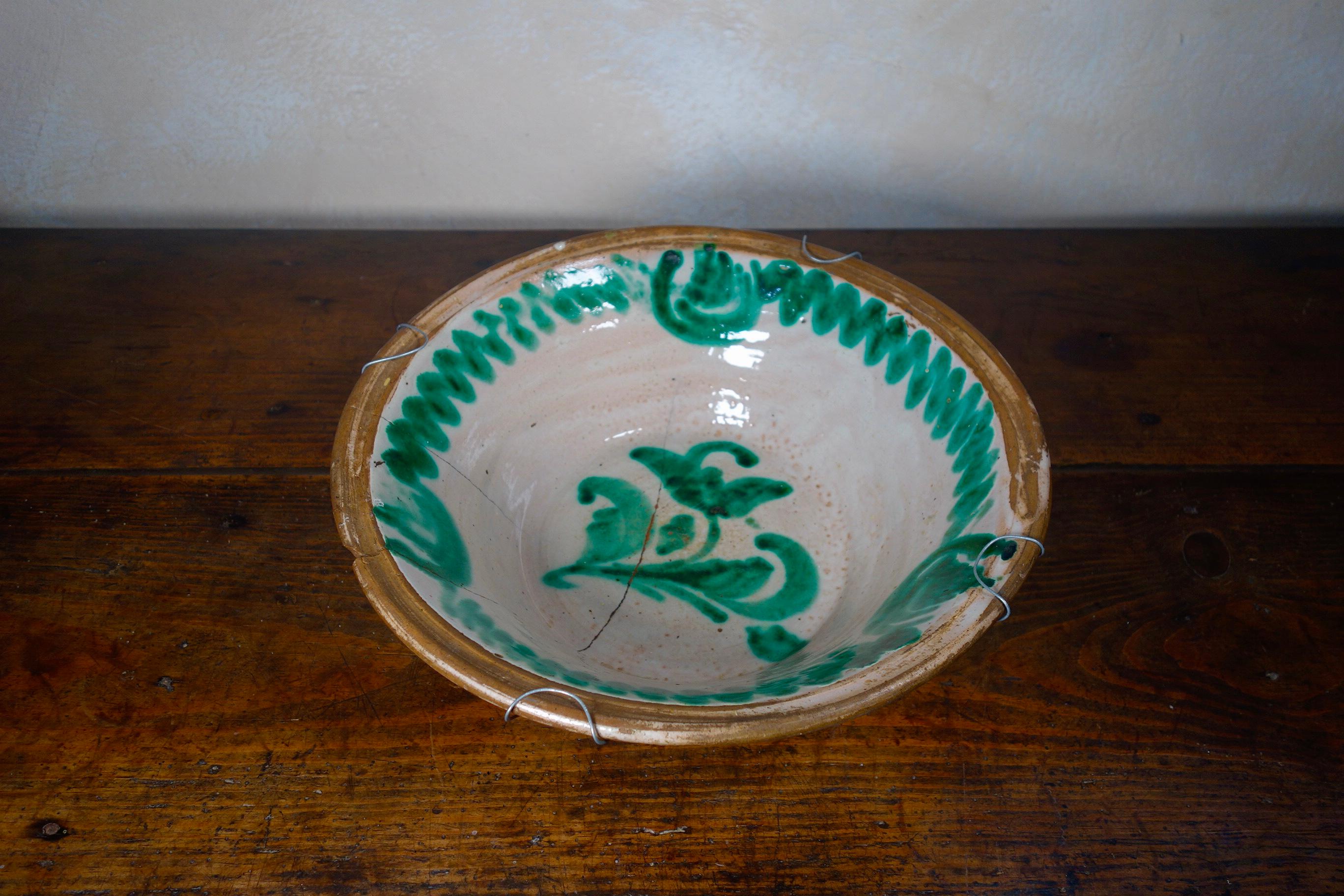 A large 1850 Spanish Lebrillo bowl earthenware originating from Granada. Featuring a lead glaze decoration in morisco green over a milk-white slip - featuring a large flower motif to the base of the bowl surrounded by smaller flowers close to the
