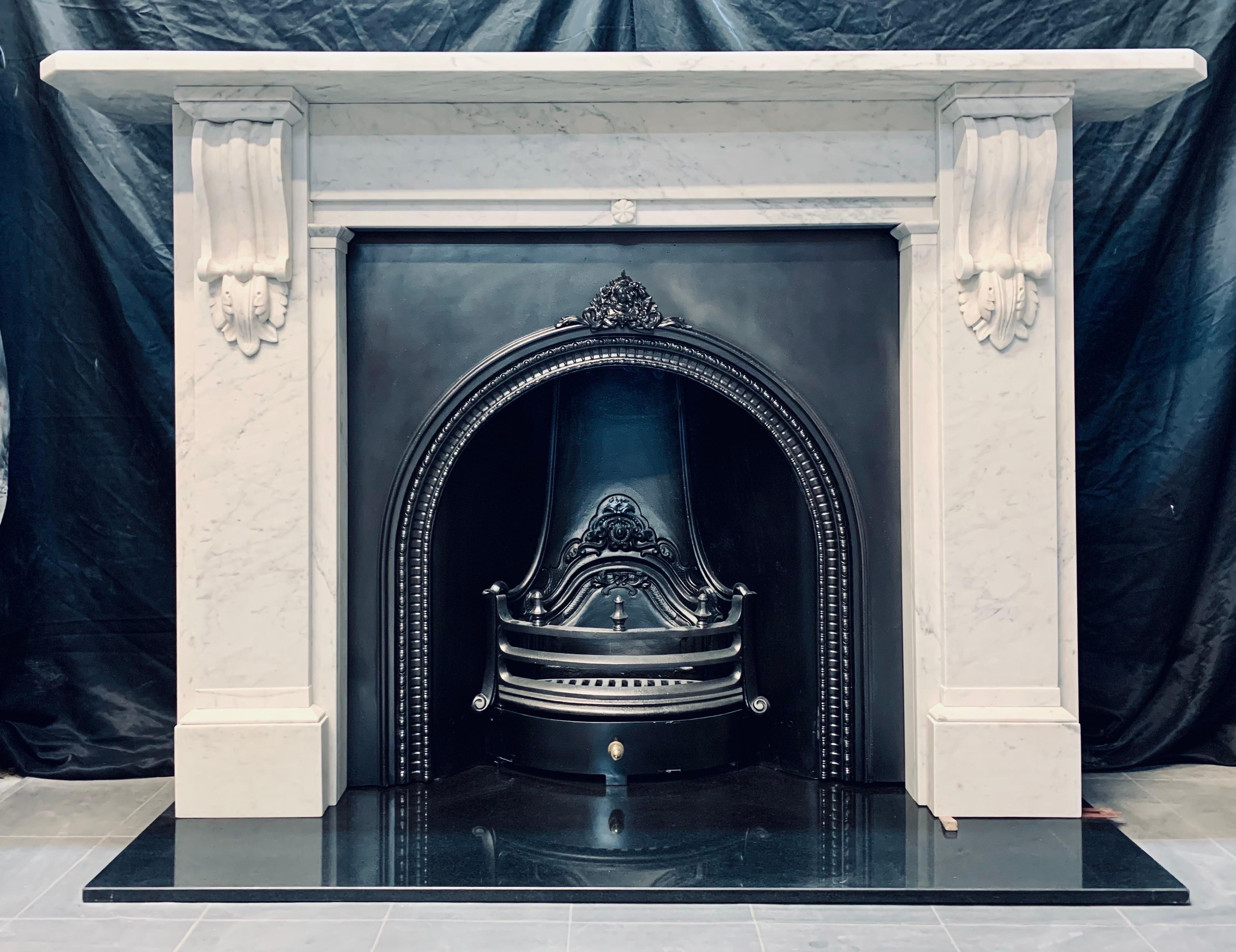 A large and versatile 19th Century Victorian lightly veined Carrara marble fireplace surround. A generous top shelf rests above a stepped frieze with a high relief central flower. Flanked by, sturdy jambs each displaying a well carved corbel with
