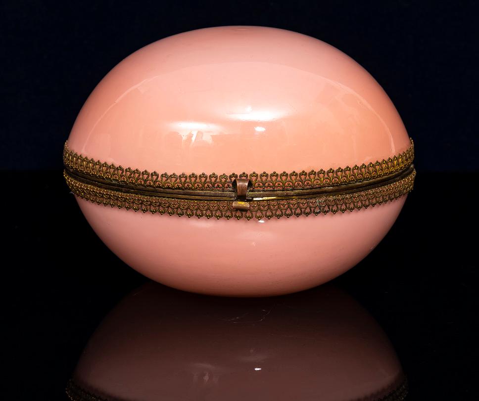 A Large 20th C. French Ormolu Mounted Pink Opaline Egg Form Covered Box. This exceptionally rare and large box, meticulously crafted from pink opaline crystal and complemented by ornate ormolu mounts, is a striking example. The ormolu mounts,