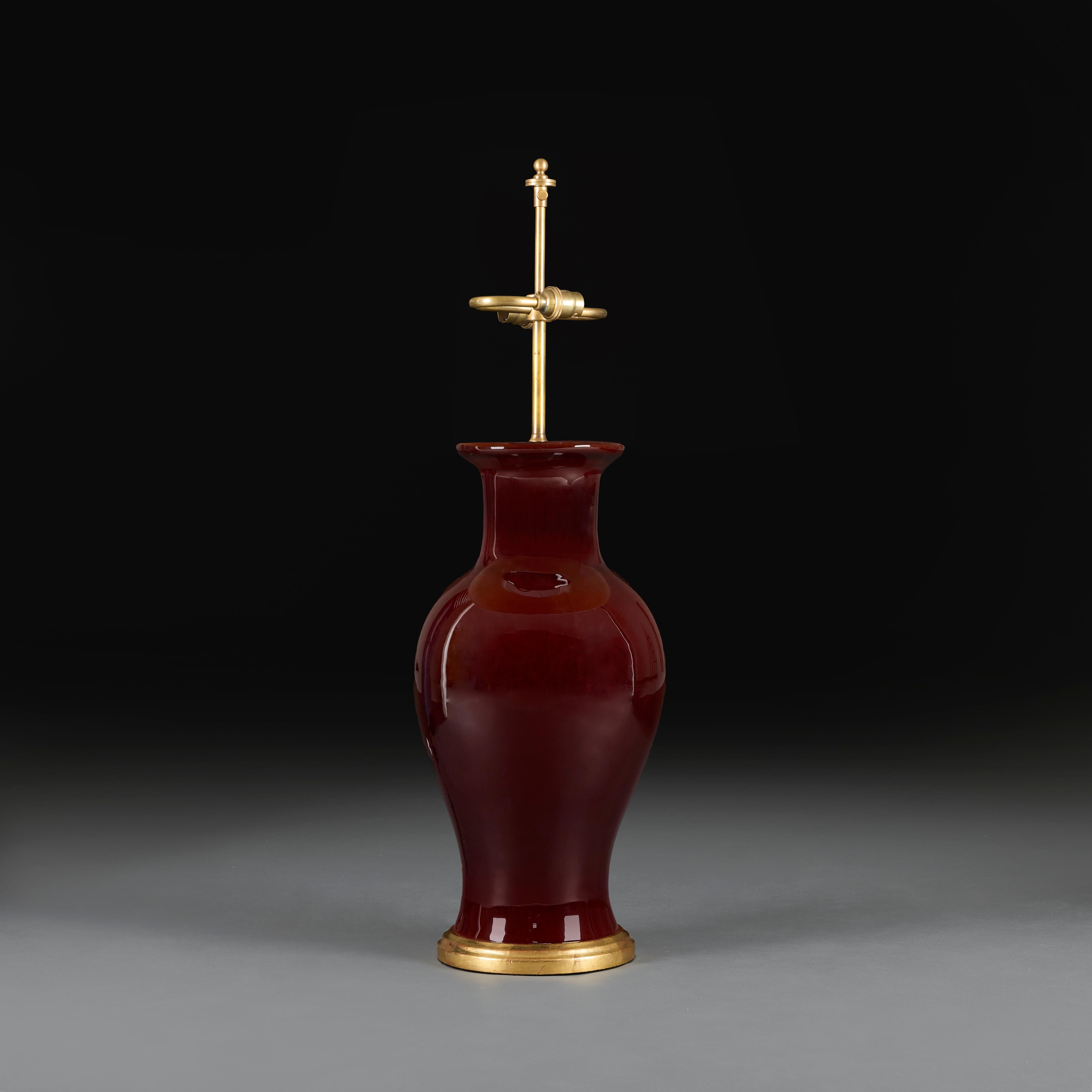 China, circa 1920
A large early twentieth century sang de boeuf vase, with deep red tones, mounted as a lamp with turned giltwood base.

Total height to finial   75.00cm
Height of vase    50.00cm
Diameter of body    22.00cm

Please note:
Lampshade