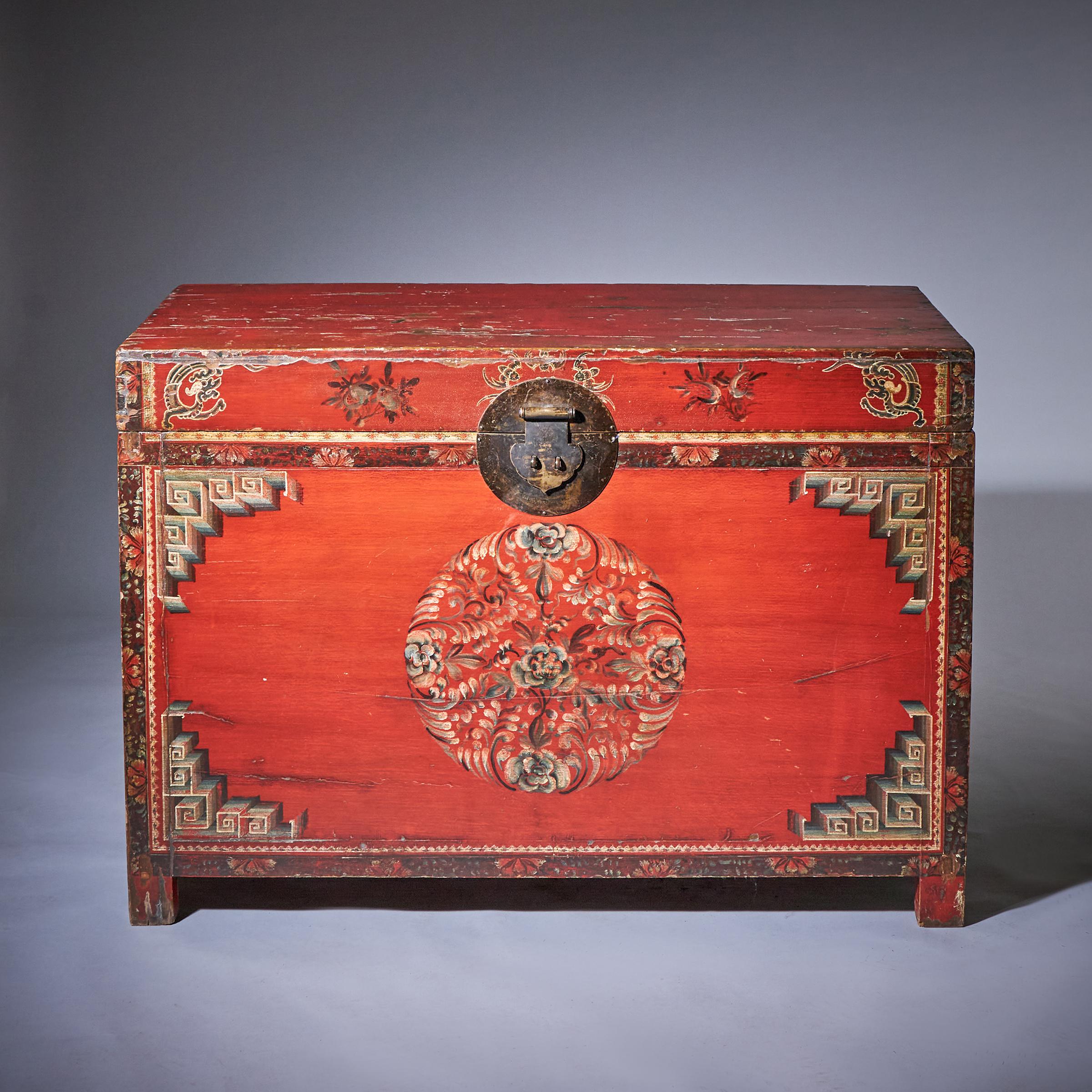 A delightful late 19th / early 20th-century Tibetan red lacquer chest of large scale, with richly patinated and distressed surfaces throughout. Attractively hand-painted with floral, leaf, greek key and dragons to the face, centered with the