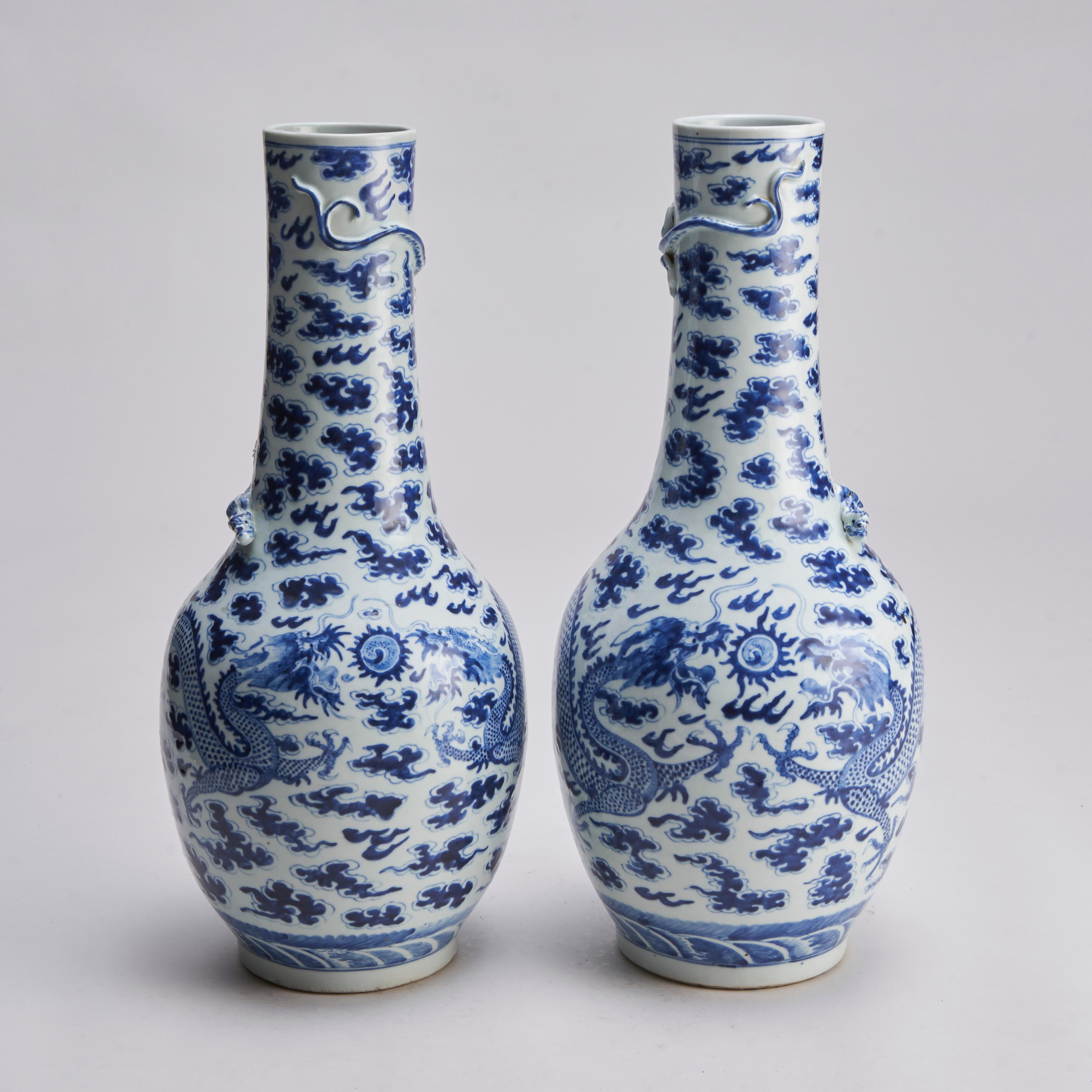From our collection of antique Chinese porcelain, a pair of 19th century blue and white bottle vases with decoration of dragons among clouds. A lower border of rolling seas and moulded decoration of dragons to the neck.

Contact us for further