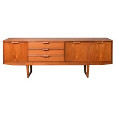A large 80” mid century modern teak sideboard featuring sleigh legs