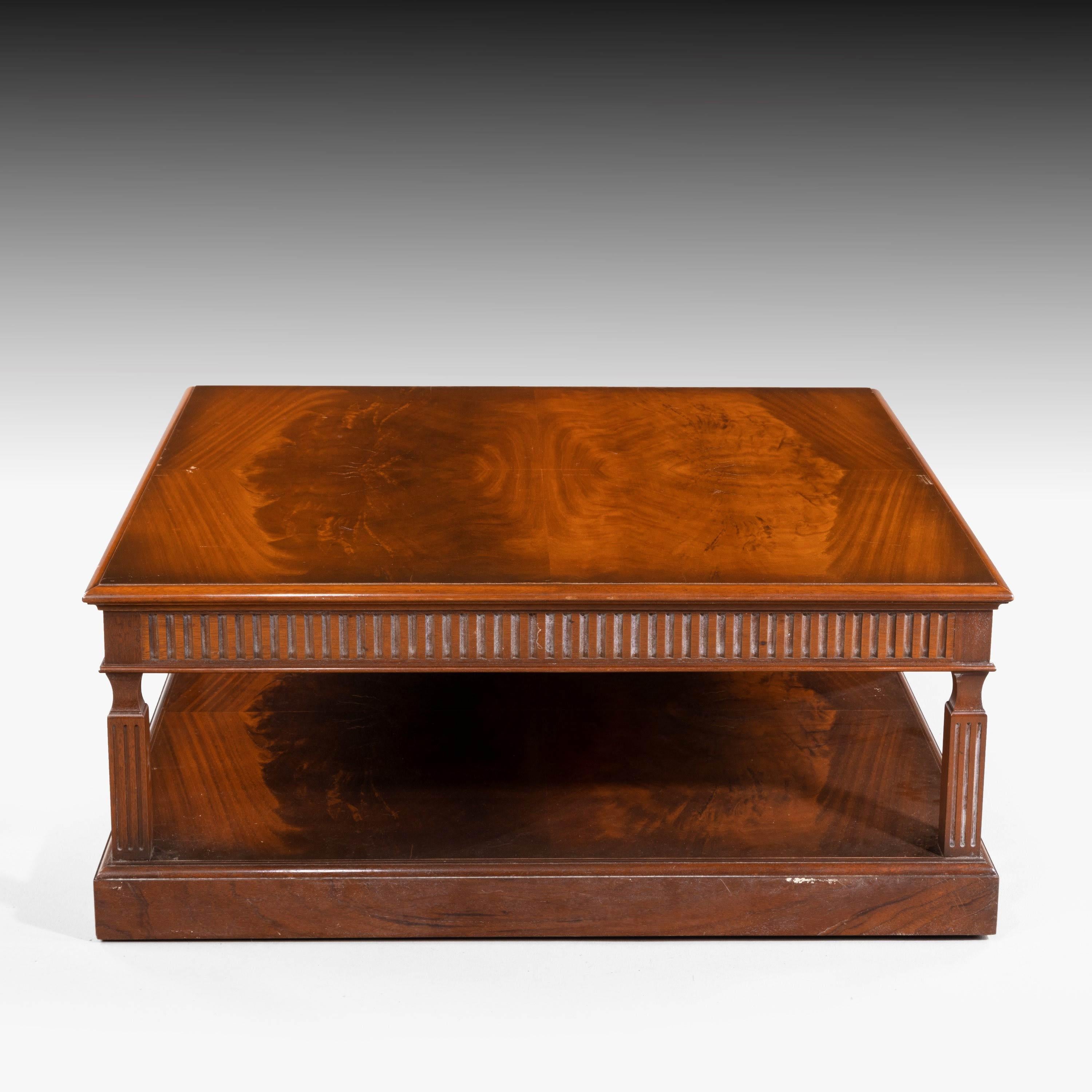 An attractive, large, square coffee table. With a well carved reeded decoration and on four carved supports with an under shelf. Very highly figured timbers. Signed by Charles Barr on a brass plate. T.