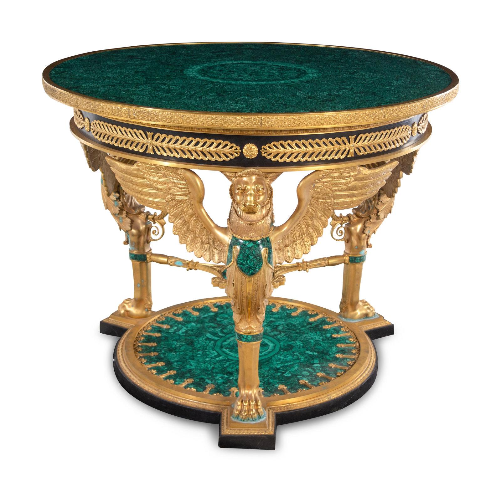 An impressive Empire style Gilt Bronze & Malachite Gueridon. The circular malachite inset top contained in a floral decorated ring, above a frieze featuring alternating rosettes and anthemia, the whole supported by three winged gryphons joined by a