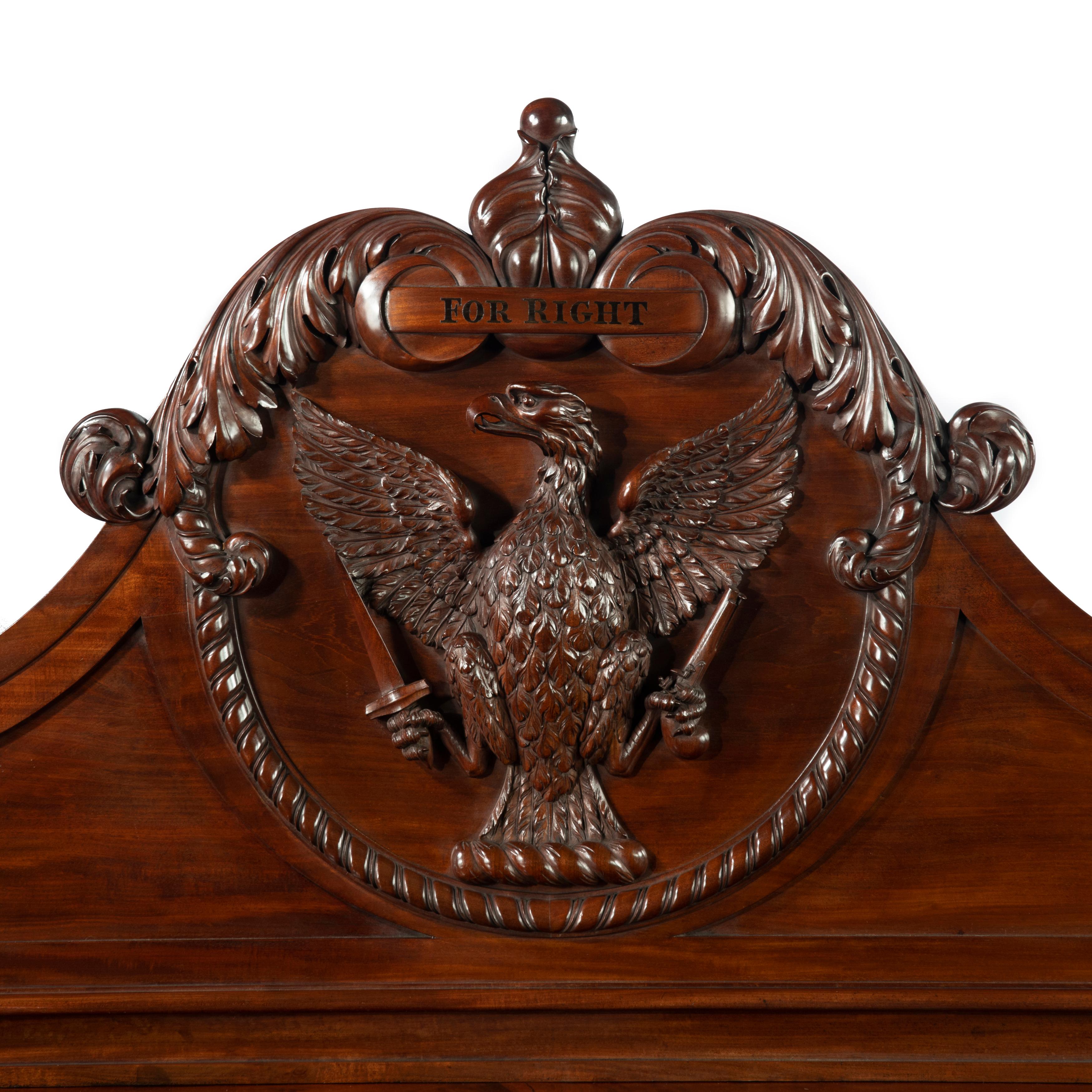 A large and impressive George IV mahogany serving table, the rectangular top surmounted by a carved back with a central cartouche of an eagle with outstretched wings holding a pistol and a dagger in its talons, below the legend ‘For Right’ all