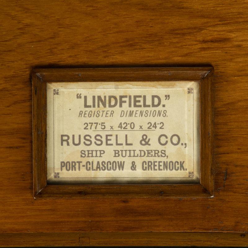 A large and impressive half hull model of Lindfield, 1891 This builder’s half hull model of a four-masted barque is made from maple and mahogany.  The hull is finished in natural wood and the topsides are painted black with a white gunport band and