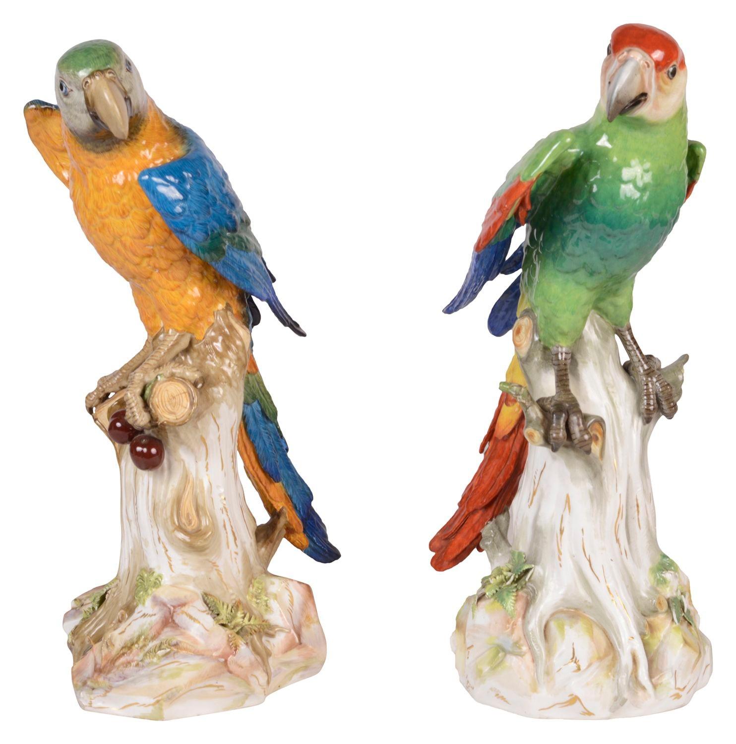 Une grande et impressionnante paire de perroquets merveilleusement colorés, modelés de façon naturaliste, l'un tenant des cerises dans sa patte, tous deux perchés sur des souches d'arbres.
Épées croisées bleues sur le dessous. Mesure : 43cm de