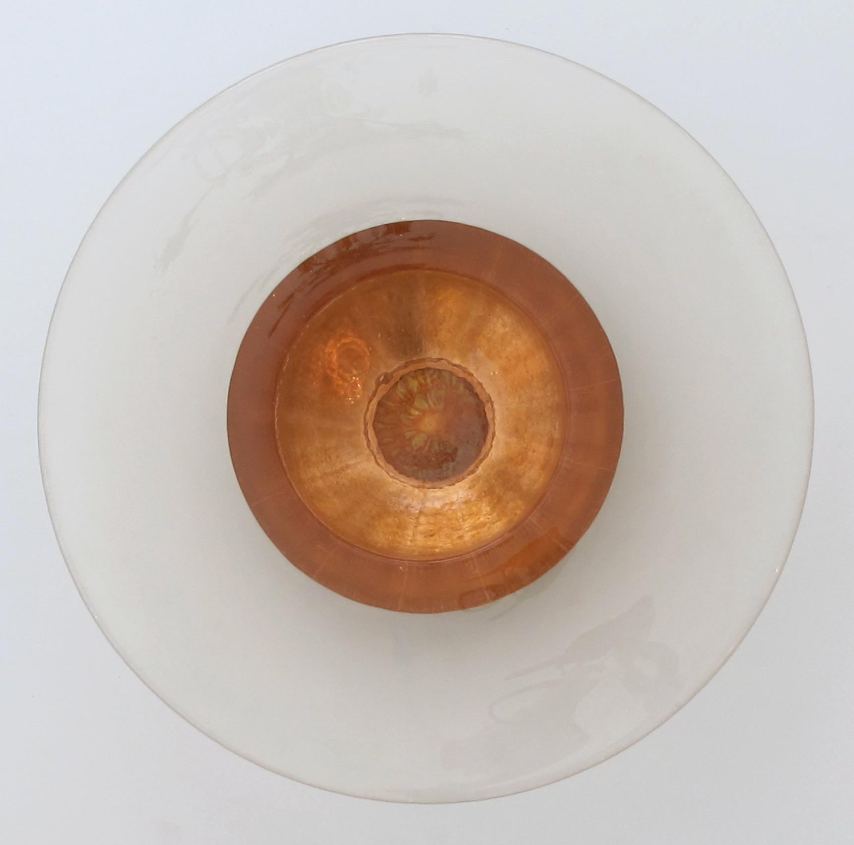The impressively large cast bowl with copper metal leaf adornment; George Bucquet and his small team of artisans use a process of pouring hot glass, thick and translucent, into handmade molds; after up to eight days of cooling, each piece is hand