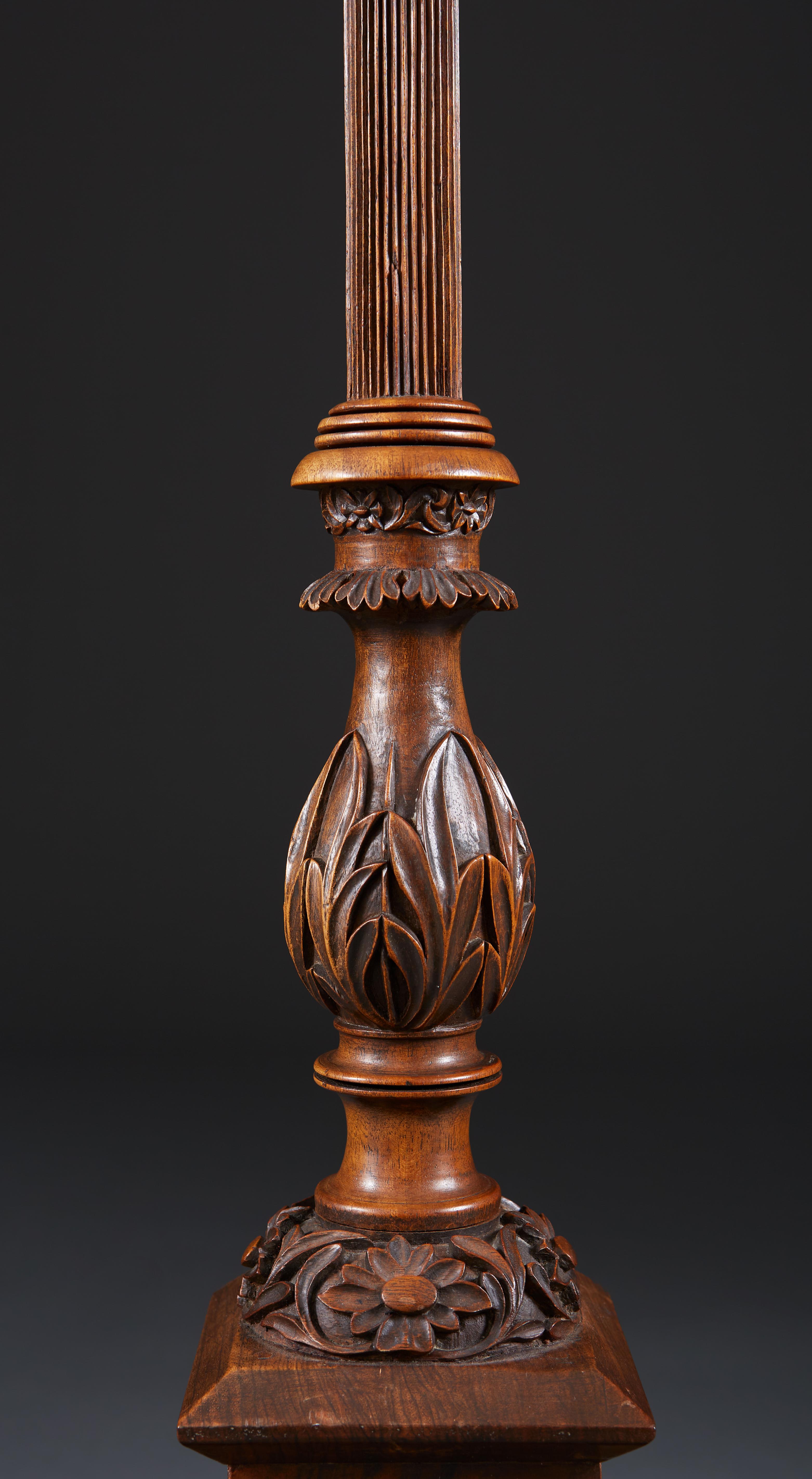 An Anglo-Indian carved stained hardwood table lamp, the reeded stem above a foliate baluster descending to a stepped square base, carved with foliage and outscrolled corners.

Please note: lampshade not included.

Currently wired for the UK.
