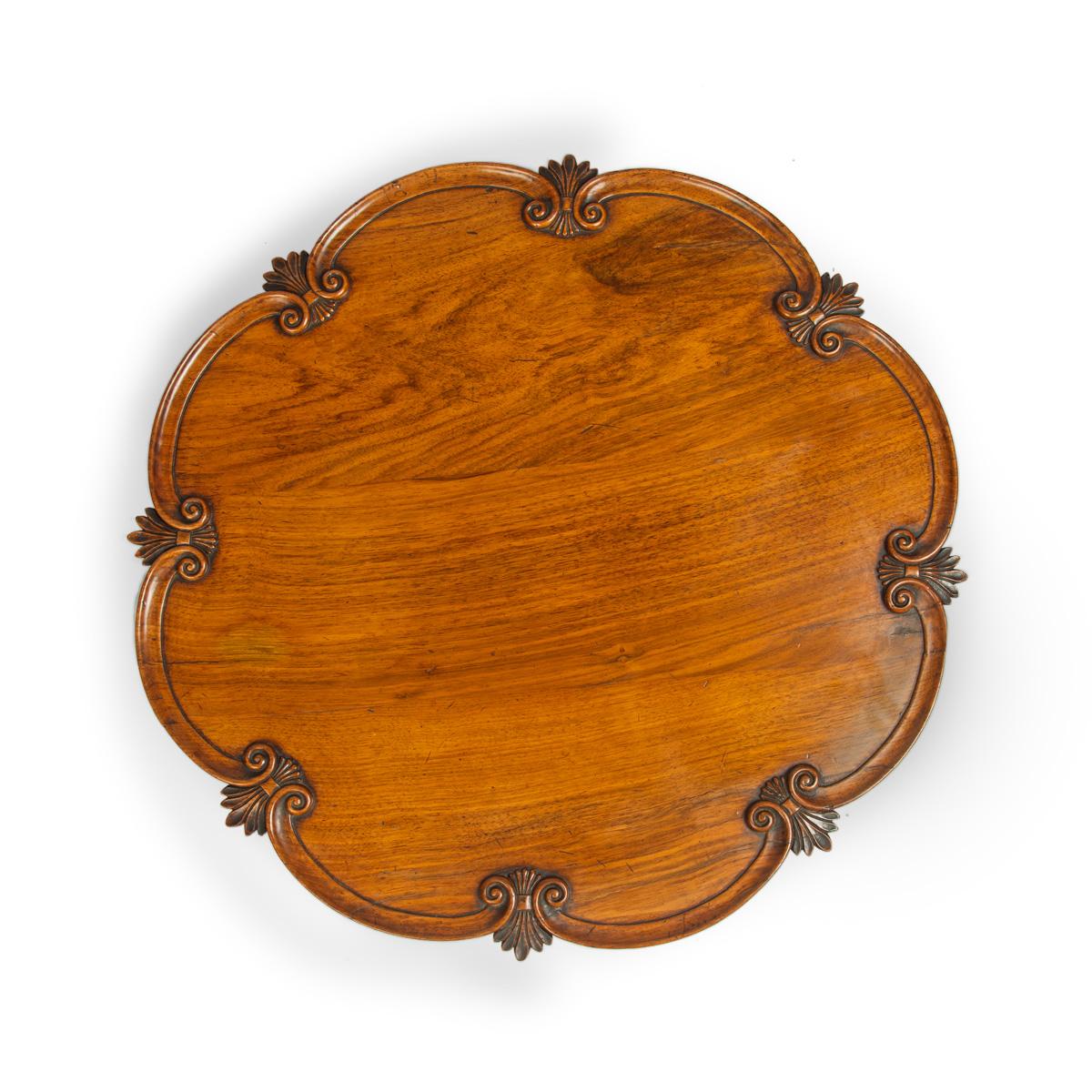 Un grand Lazy Susan en bois de padouk anglo-indien, le plateau circulaire festonné sur une base tournante à huit pieds, audacieusement sculpté de rinceaux en C reliés par des anthemia et des feuilles de chêne avec des glands, chaque anthemion