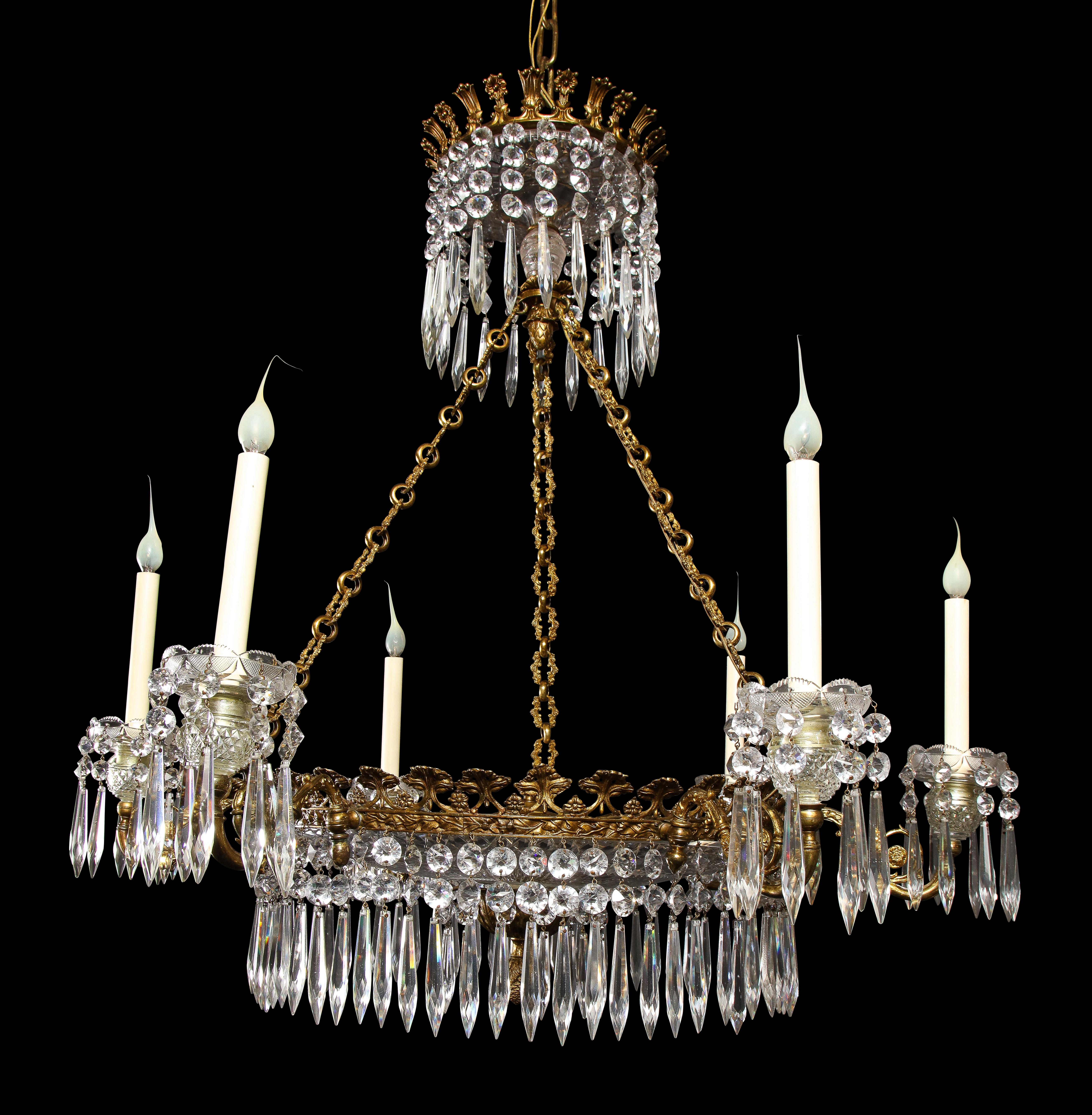 A Large Antique English Regency Style Gilt bronze and cut crystal multi light chandelier of superb craftsmanship. This fine chandelier is embellished with a large cut crystal circular central dish and further adorned with fine cut crystal prisms.