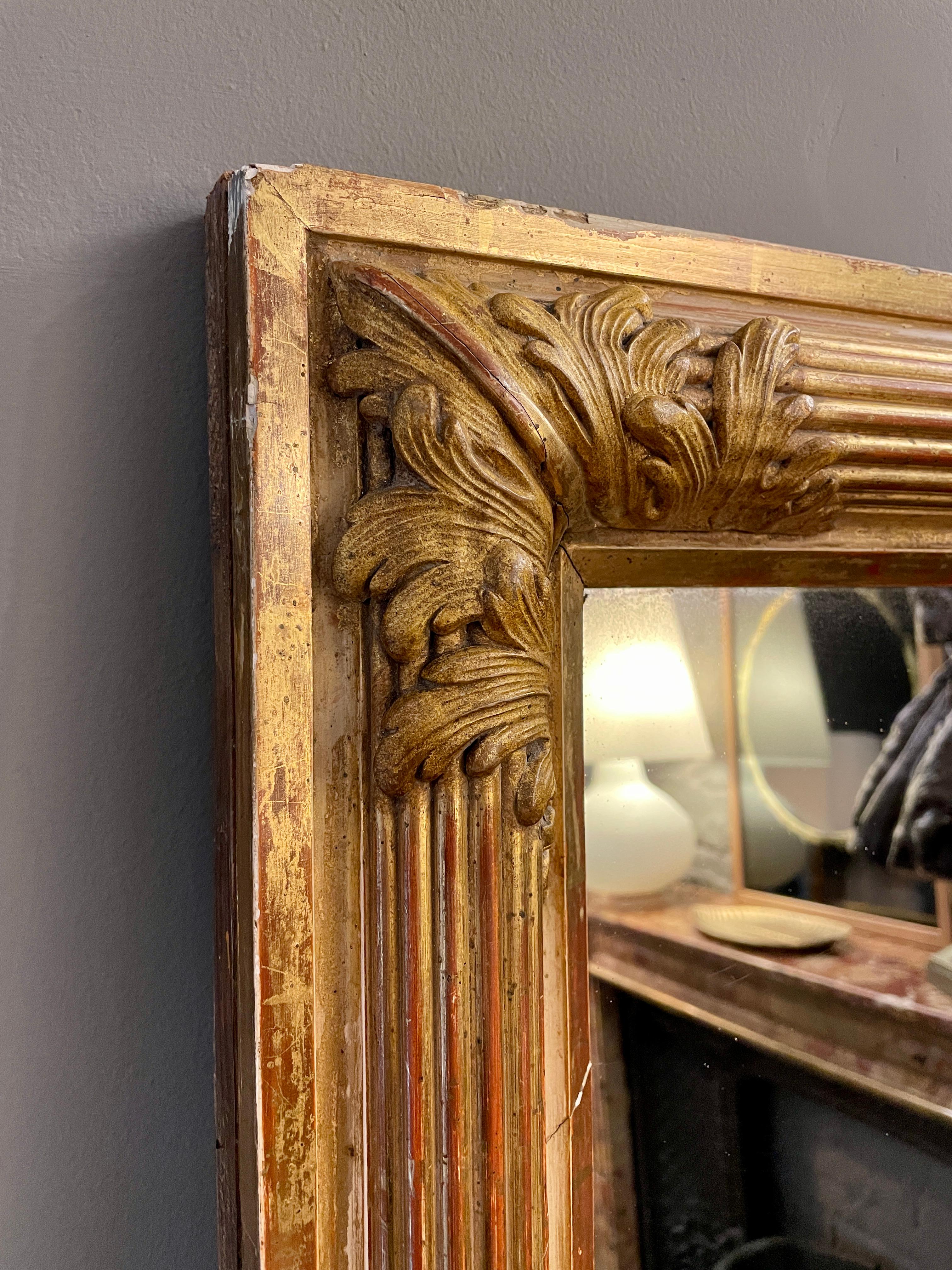 A large 19th century French gold gilt mirror, with a demi lune reeded frame the corners decorated with acanthus leaf. Original mirror plate and in good order.