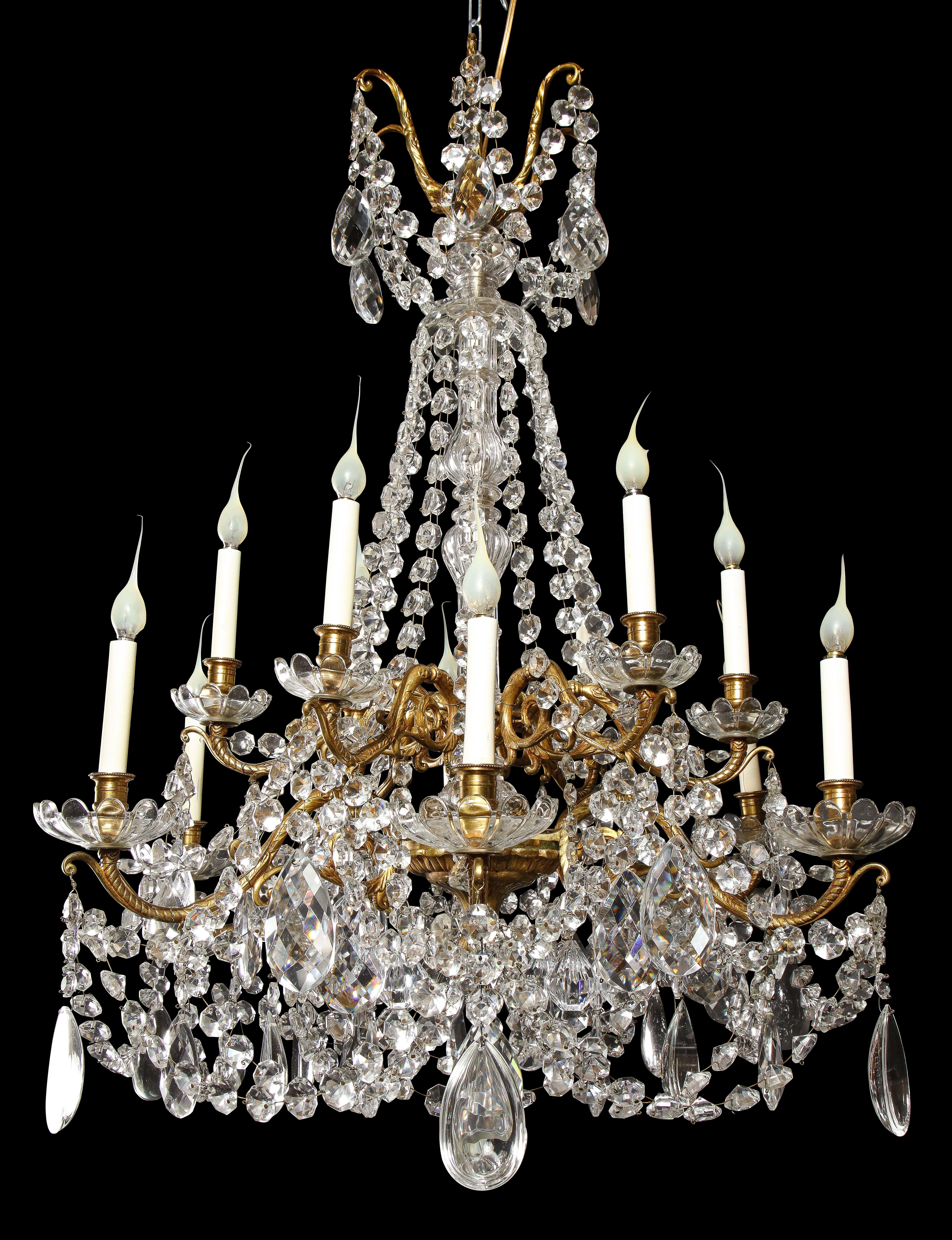 A Superb Large Antique French Louis XVI style gilt bronze, cut crystal and glass twelve arm double tier chandelier of great detail. This fine chandelier consists of 12 gilt bronze arms embellished with glass bolbeches, further adorned with cut
