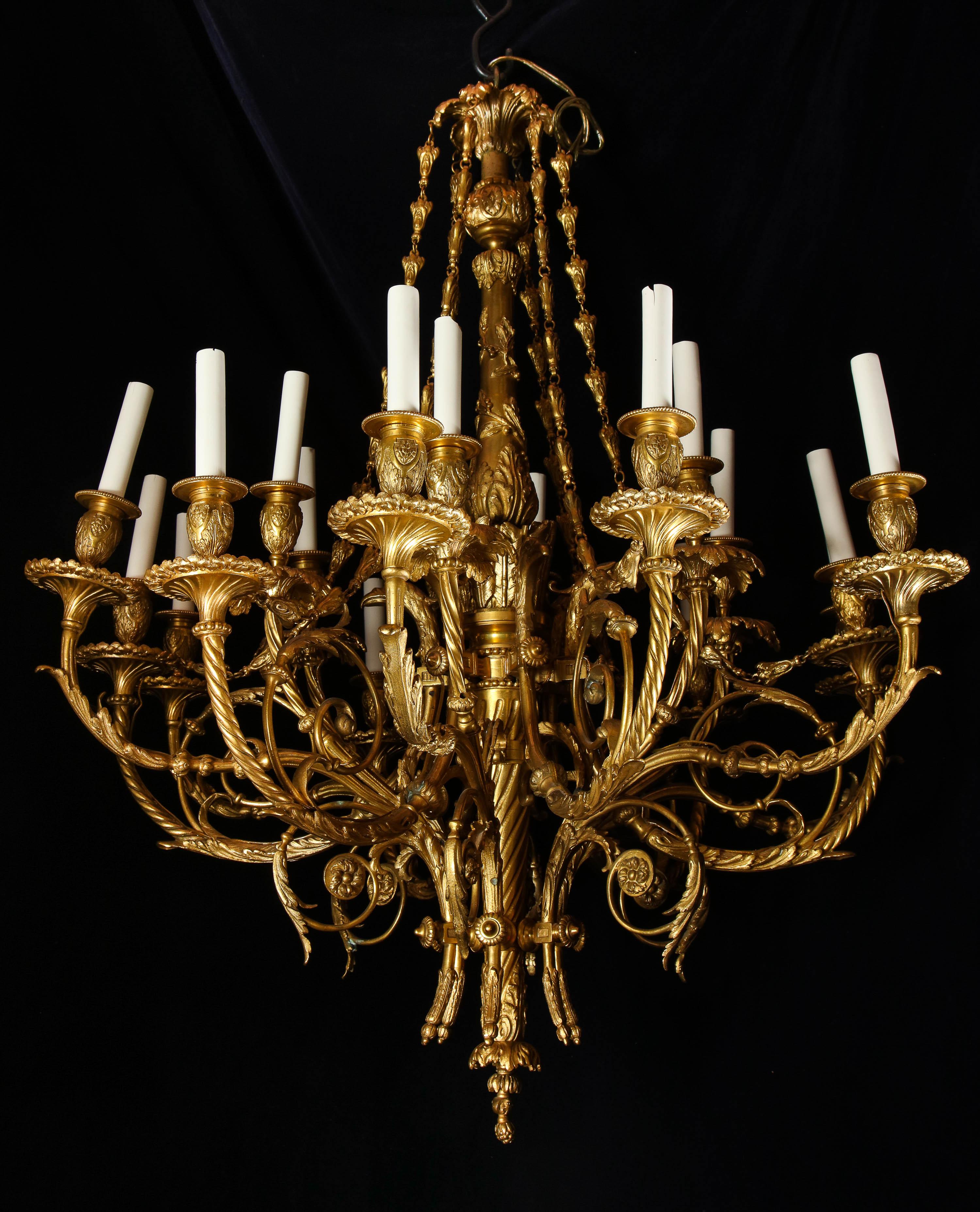 A fine and large antique French Louis XVI style double tier multi light gilt bronze chandelier of superb quality embellished with figural masks of eagles and further adorned with finely casted gilt bronze chains.