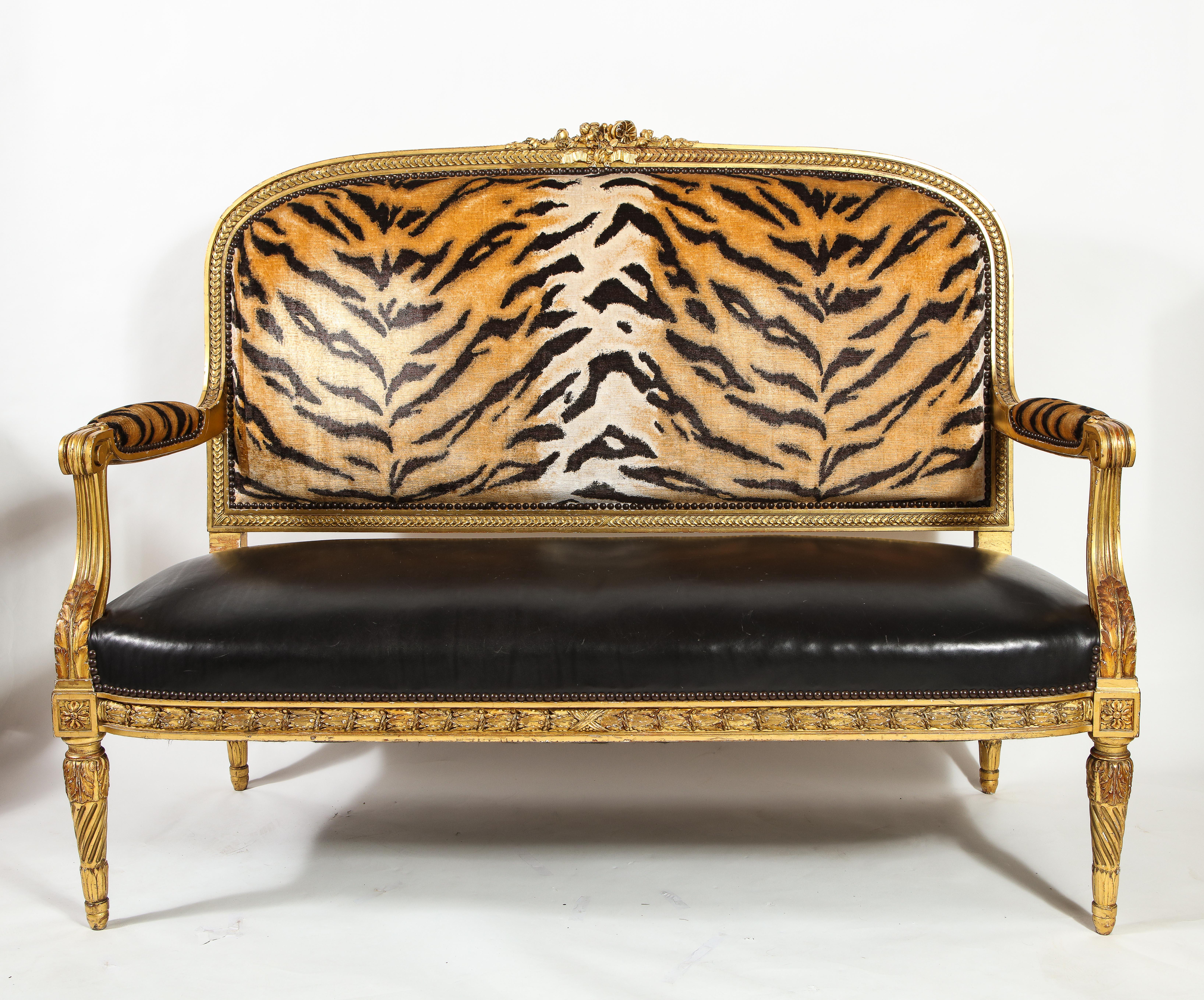 Großes antikes französisches Sofa im Louis-XVI-Stil, handgeschnitzt aus vergoldetem Holz, Ende des 19. Der Rahmen ist aus geschnitztem Holz mit wasservergoldeter Oberflächenbehandlung gefertigt und weist ein zentrales florales Wappen an der