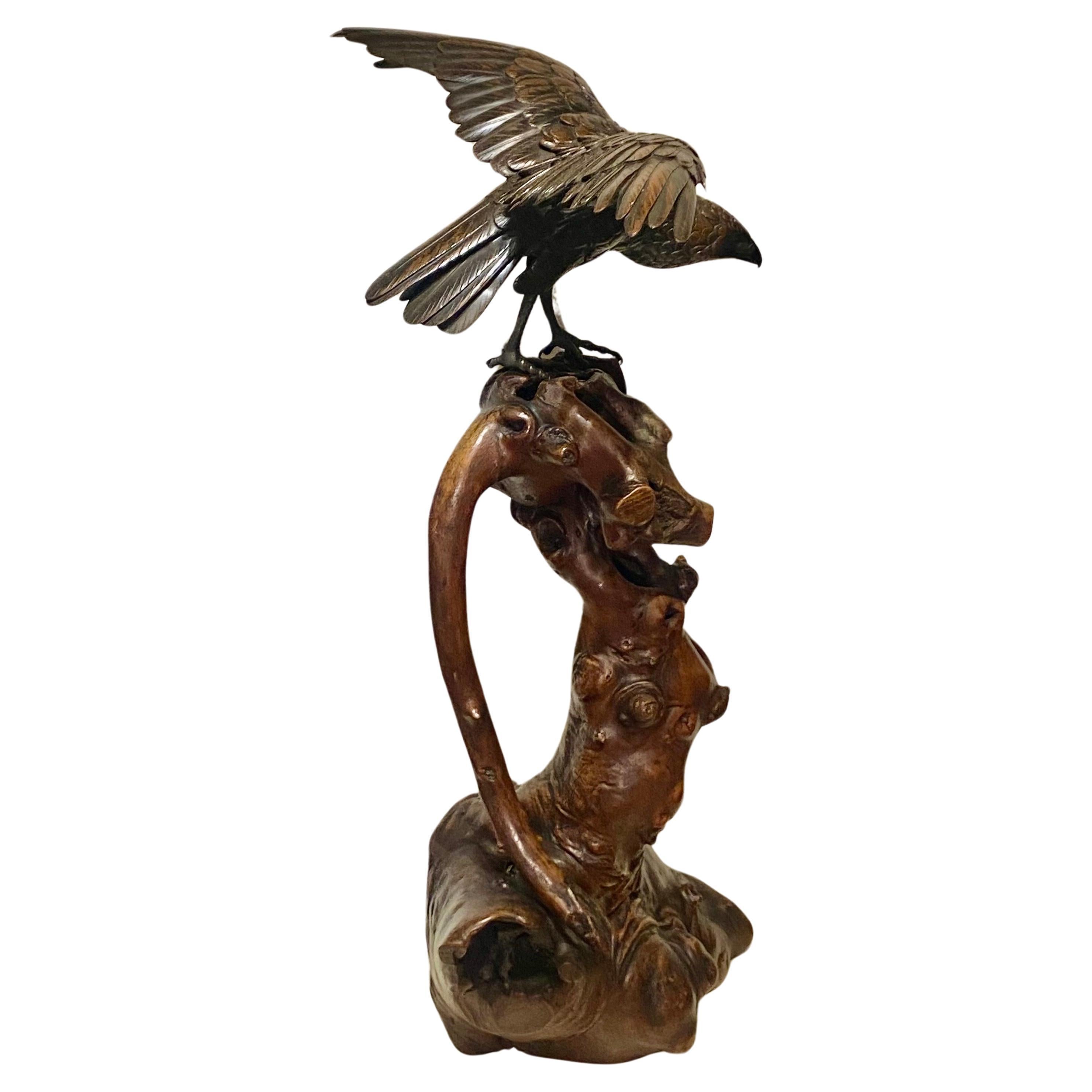 Japanischer Bronzeadler, modelliert mit ausgebreiteten Flügeln und gesenktem Kopf, 
Alle Federn sind fein geschnitzt und haben eine reiche braune Patina. Sie stehen auf einem Sockel aus Wurzelholz und sind auf einer rechteckigen Reserveplakette