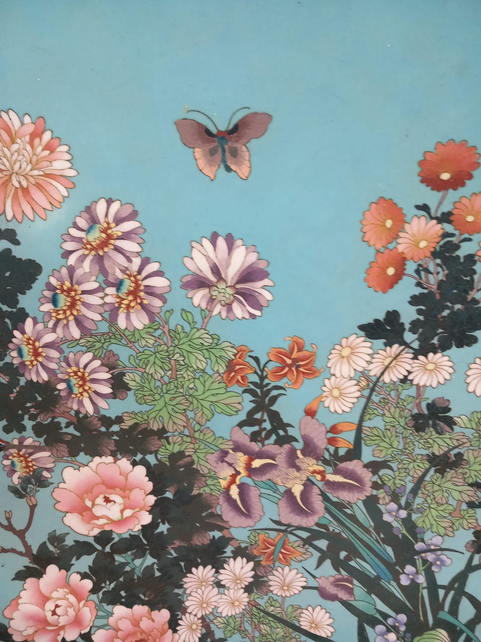 Un grand chargeur japonais antique en émail cloisonné de la période Meiji, datant du dernier quart du XIXe siècle.
Le chargeur est décoré d'une cigogne volante devant un magnifique éventail de fleurs telles que chrysanthèmes, pivoines, myosotis,