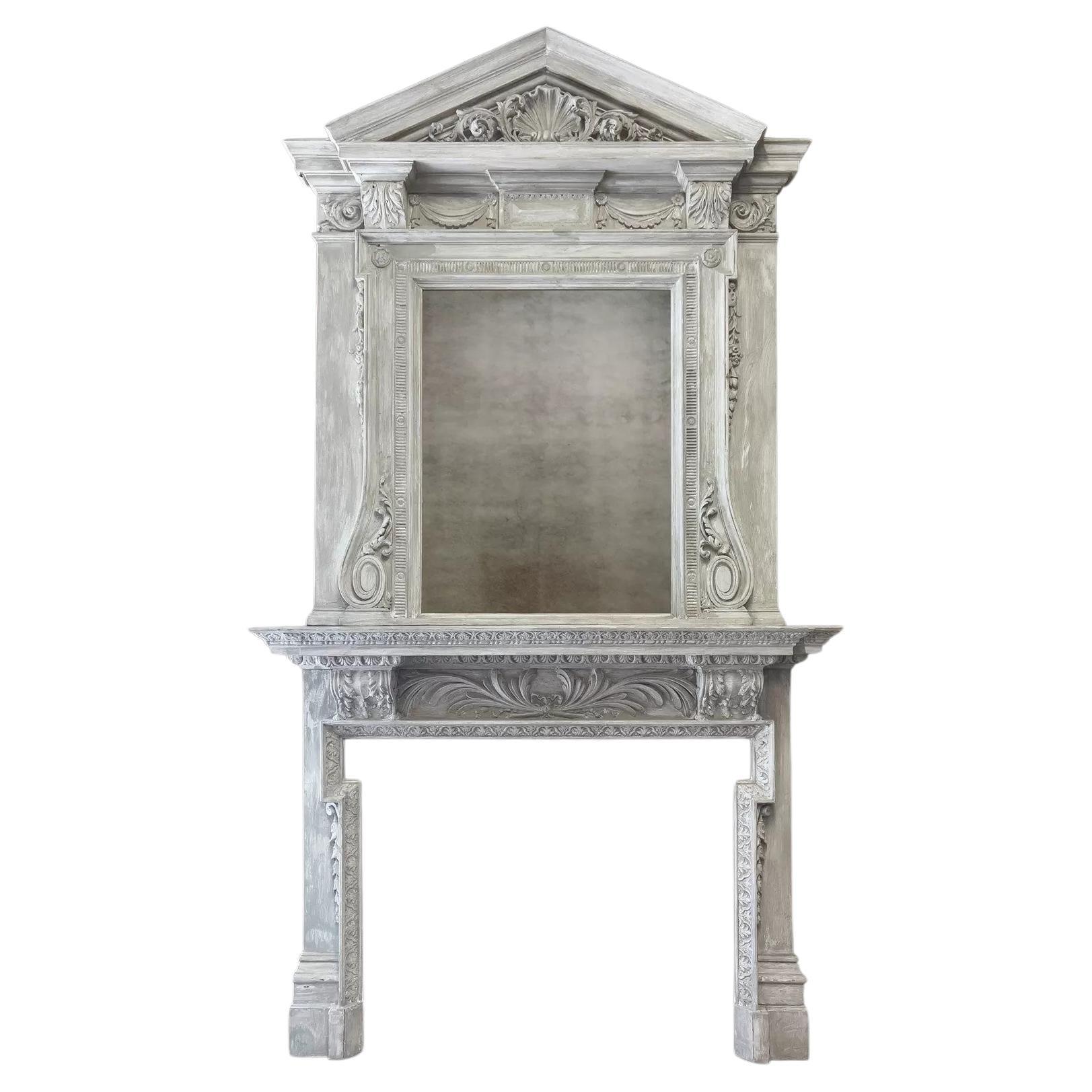 A large antique painted wooden fireplace with overmantel mirror