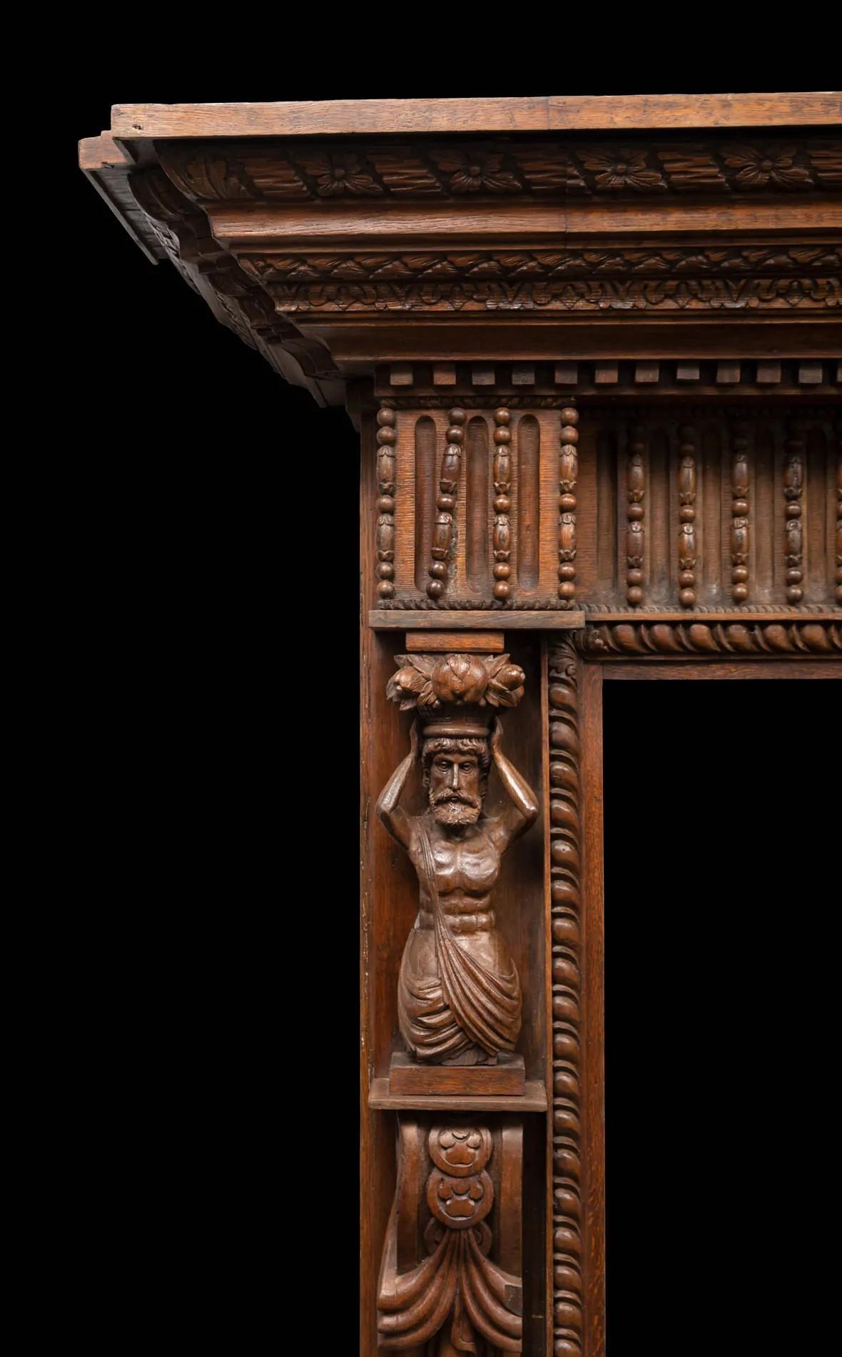 A large antique profusely carved oak fireplace surround in the Jacobean style
Made during the Victorian period in England, incorporating 17th century and 18th century carved elements.

The carved console jambs with male caryatid supports, the acorn