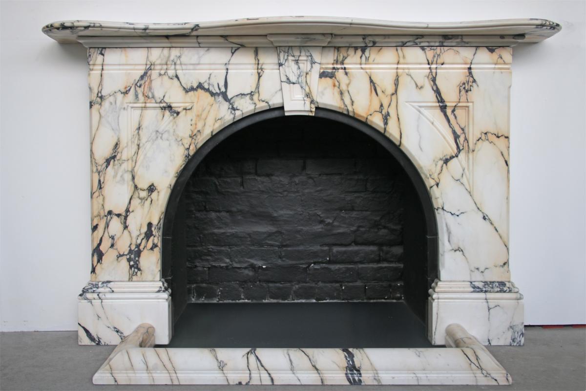 A Large antique Victorian fireplace surround in striking and well figured Pavonazzo marble with an arched aperture and moulded and shaped mantle shelf. Complete with matching marble fender Circa 1860.

This wonderful marble comes from originally