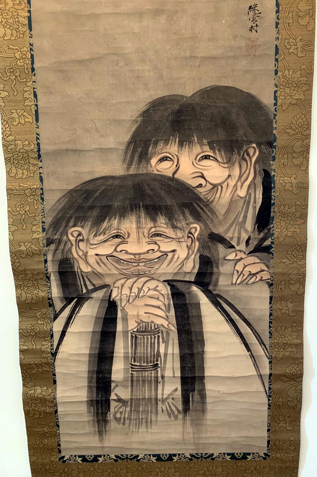 Ein japanisches Sumi-Tintengemälde mit heller Farblavierung, mit Brokatbordüren als hängende Schriftrolle (Kakejiku). Das Gemälde stellt die berühmten, exzentrischen buddhistischen Mönche Hanshan und Shide (in Japan als Kanzan und Jittoku bekannt)