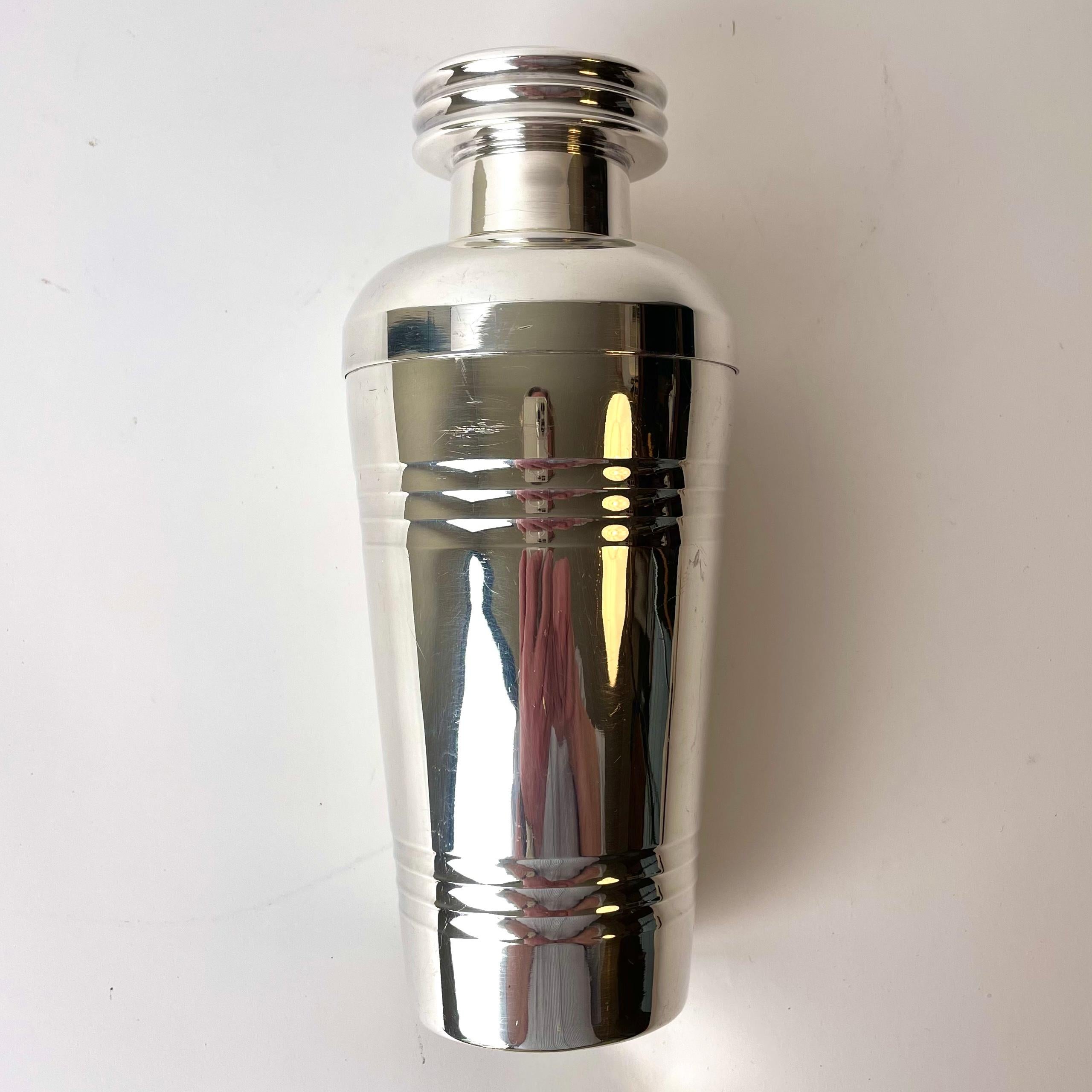 A large Art Deco silver plated cocktail shaker. Made in France during the 1920s with period design. Good condition but with a small dent on the lower part of the shaker. ( see pictures)

Wear consistent with age and use.