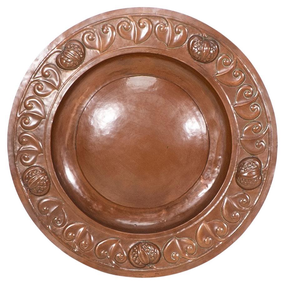 Un grande caricatore in rame decorato a mano di Decorative Crafts con decorazioni stilizzate
